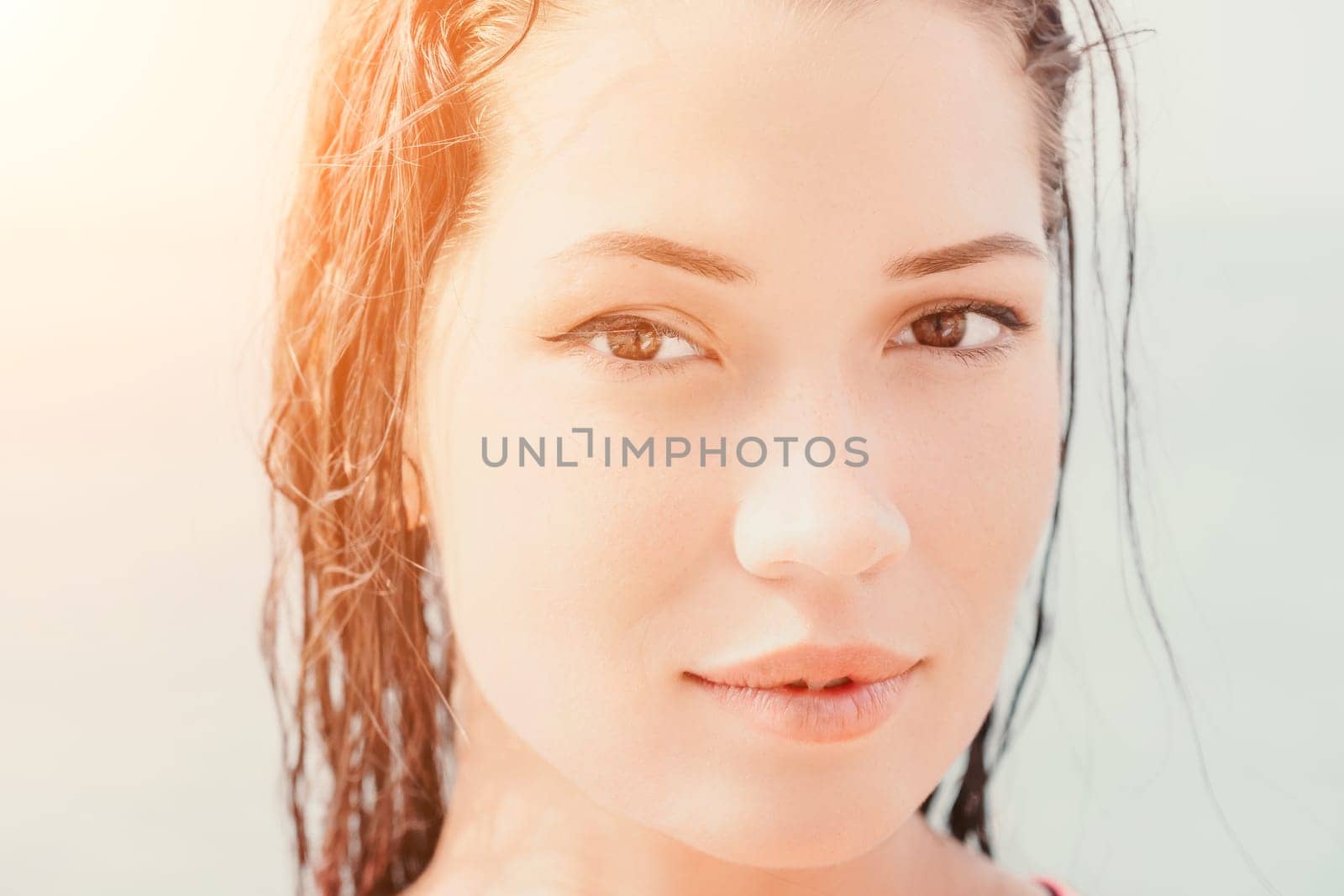 Woman sea sup. Close up portrait of beautiful young caucasian woman with black hair and freckles looking at camera and smiling. Cute woman portrait in a pink bikini posing on sup board in the sea. by panophotograph
