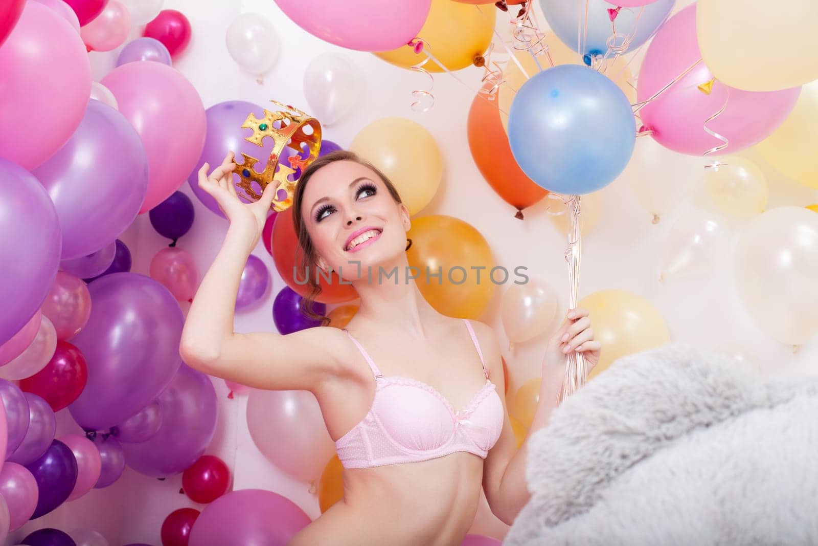 Image of cheerful young woman tries on toy crown