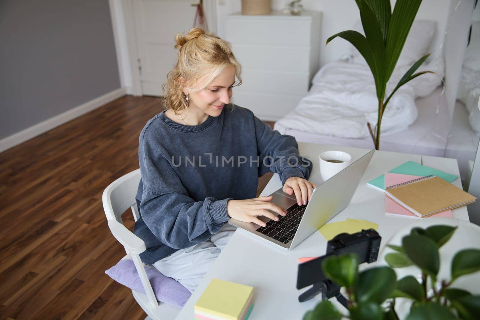 Portrait of young woman distance learning, working from home with laptop, making notes, student studying on remote, doing online course.