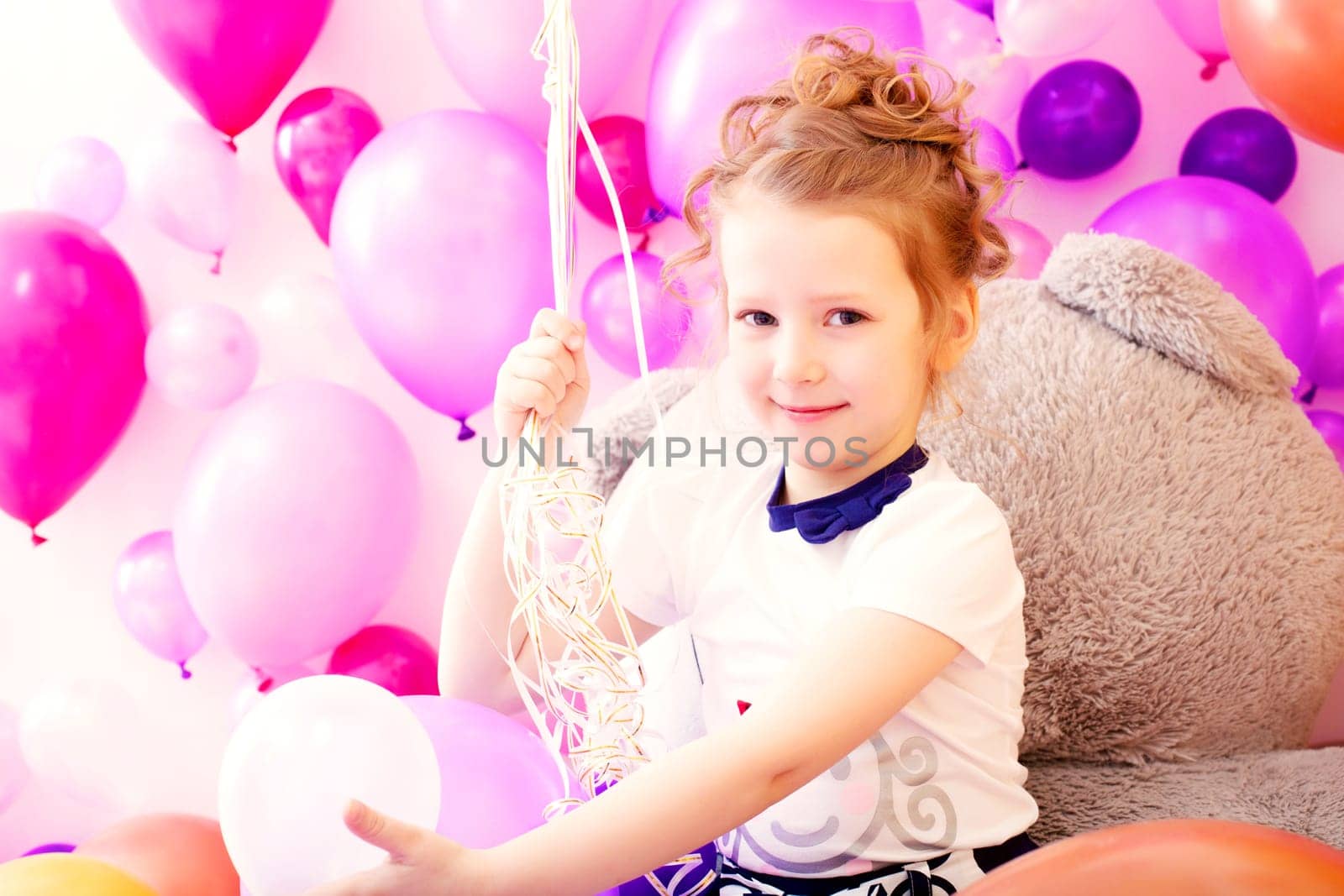 Portrait of smiling girl on colorful balloons background