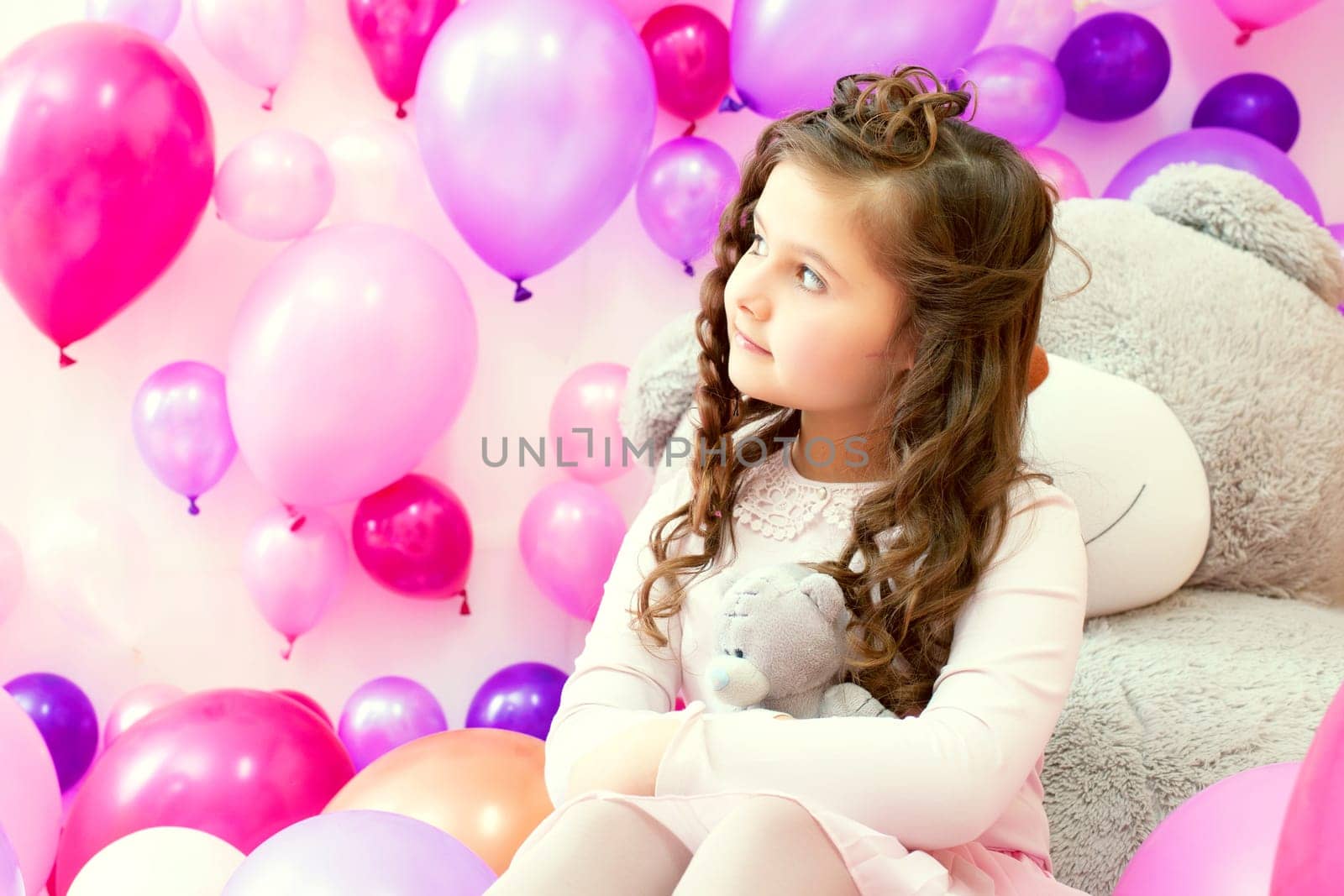 Portrait of dreamy little girl hugging teddy bear