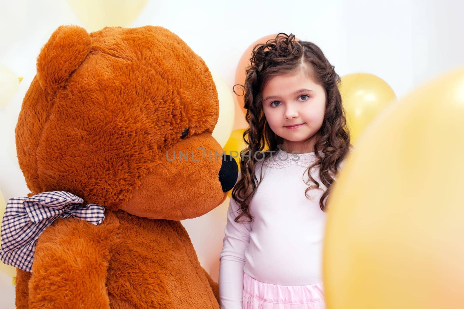 Image of cute little brunette posing with big teddy bear