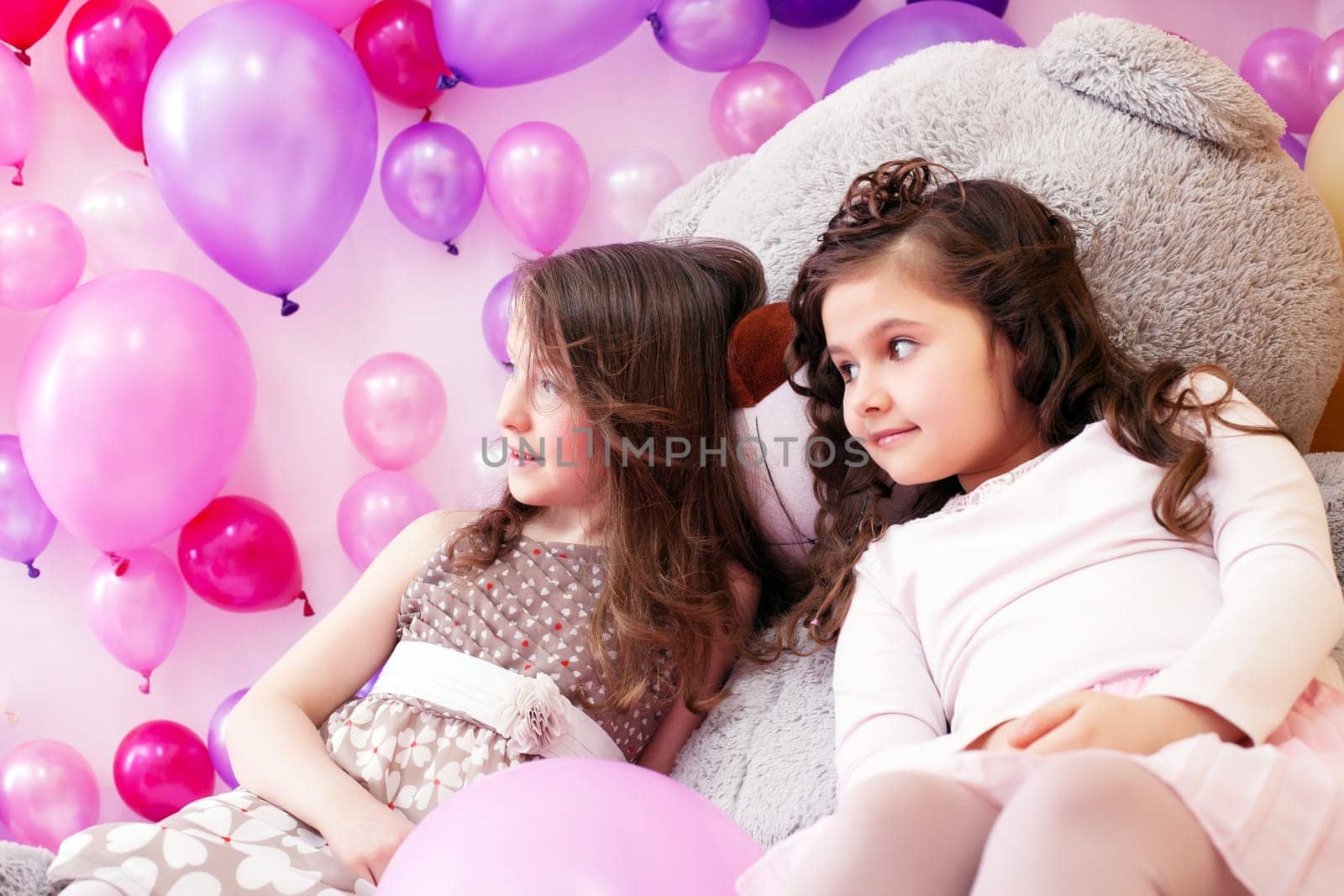 Image of elegant little girlfriends posing in playroom