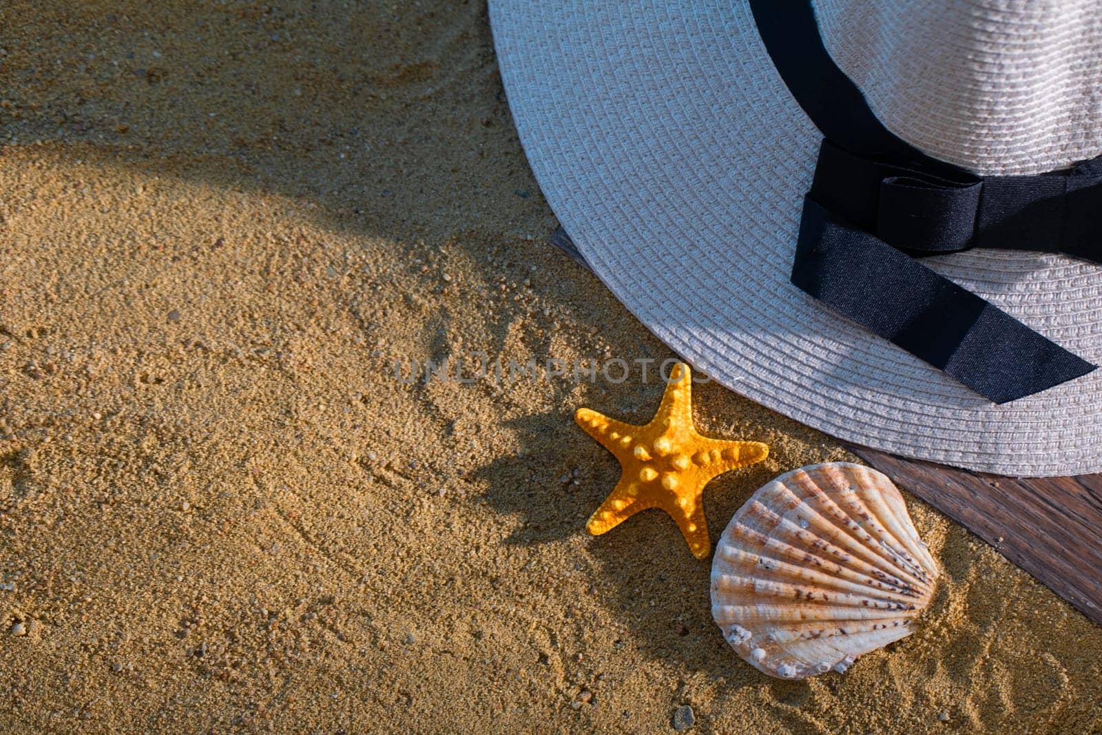 A decorative hat was laid on the sea beach and lies on a wet squeak.