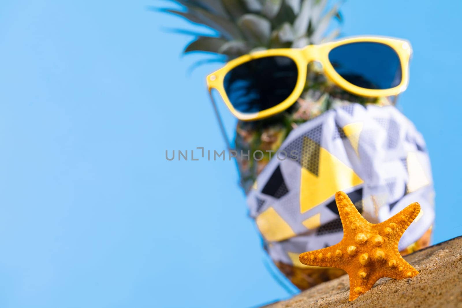 Ripe pineapple. Protective mask. Sunglasses with a yellow frame. Sea beach. Sunny day.