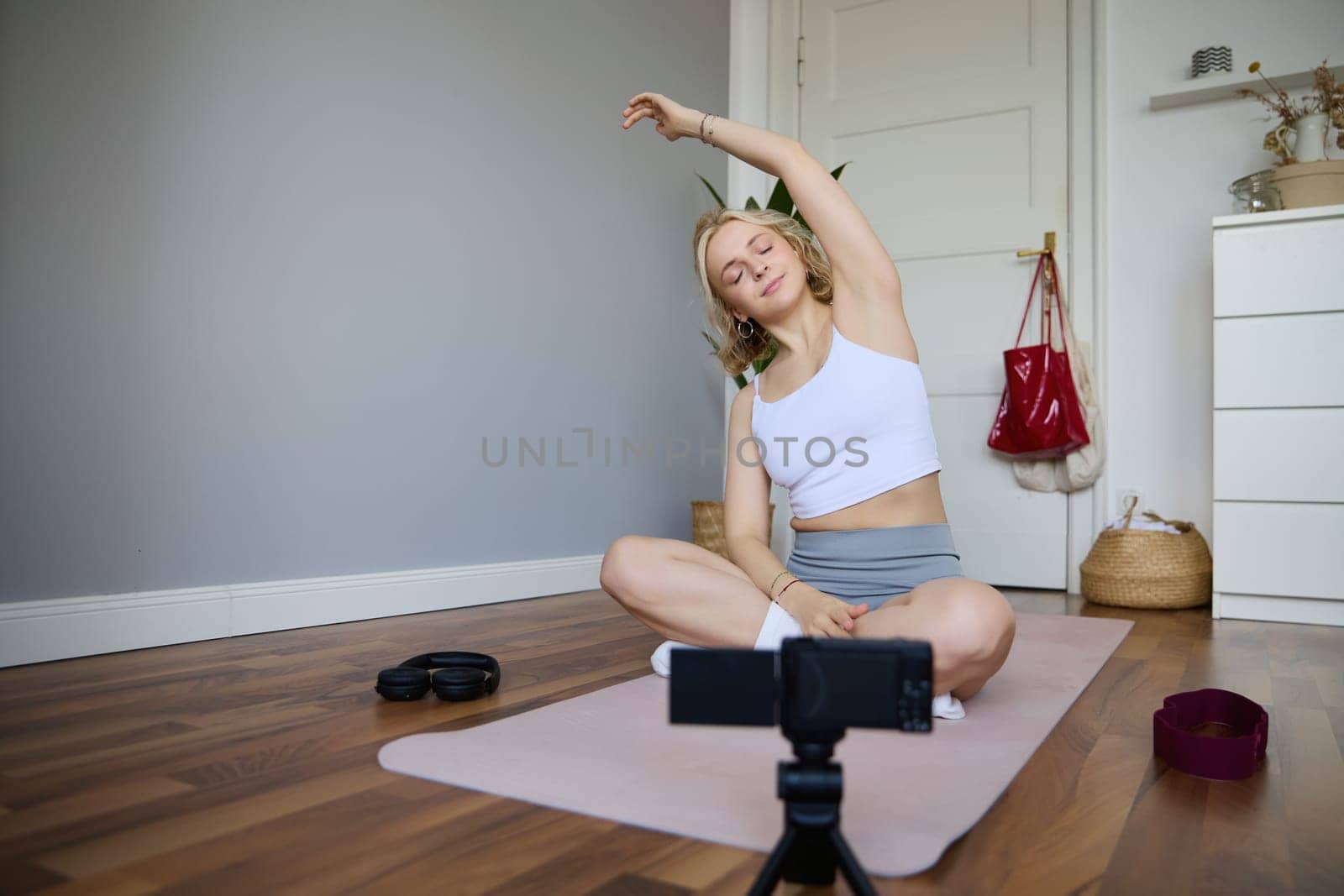 Young athletic woman trainer practicing Hatha Yoga, instructor personal training Vasisthasana, balancing pose, workout at home. Concept of healthy lifestyle and wellbeing by Benzoix