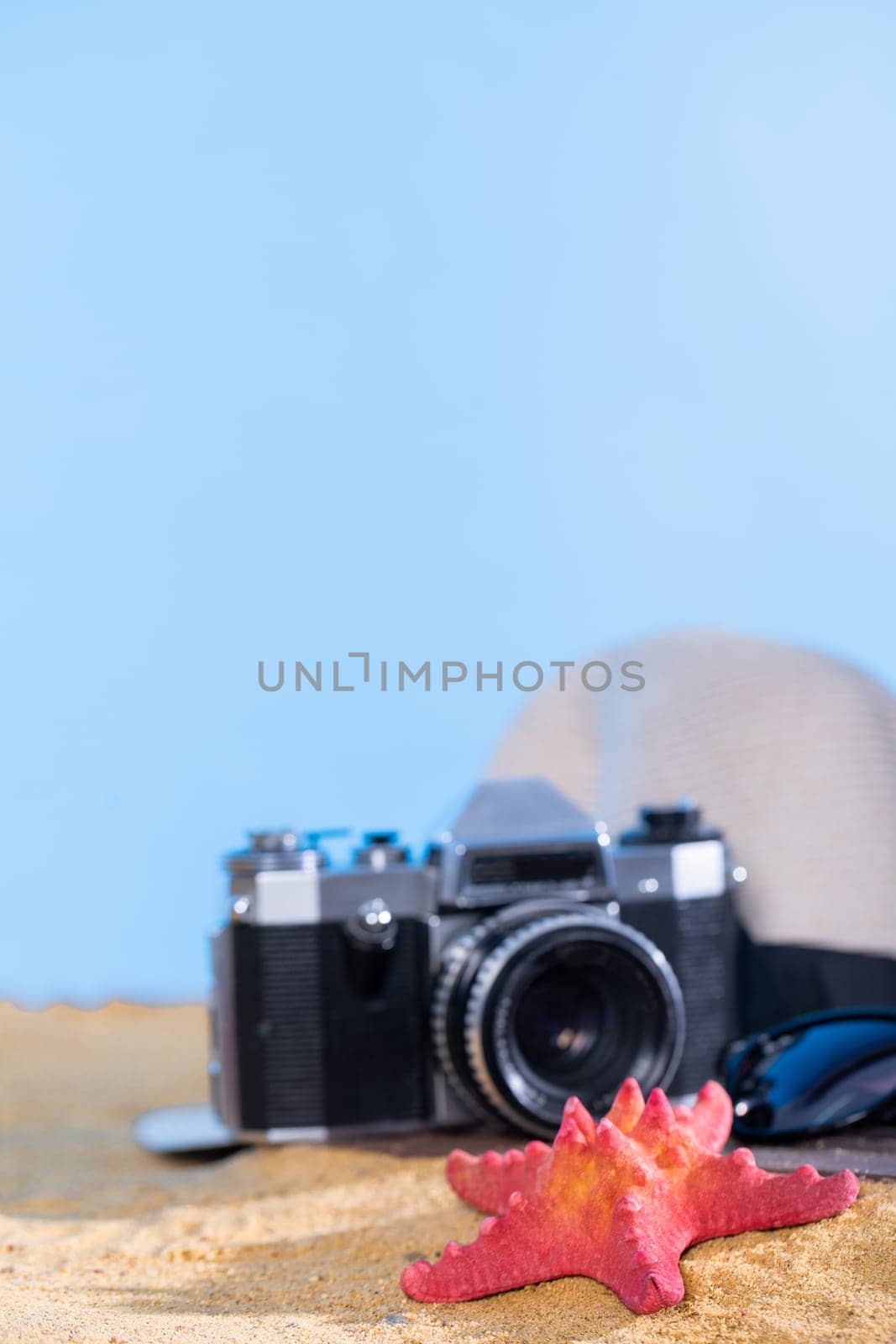 The beach is full of accessories for tel blue sky, which are necessary for every holiday. Sun hat. Old camera by fotodrobik