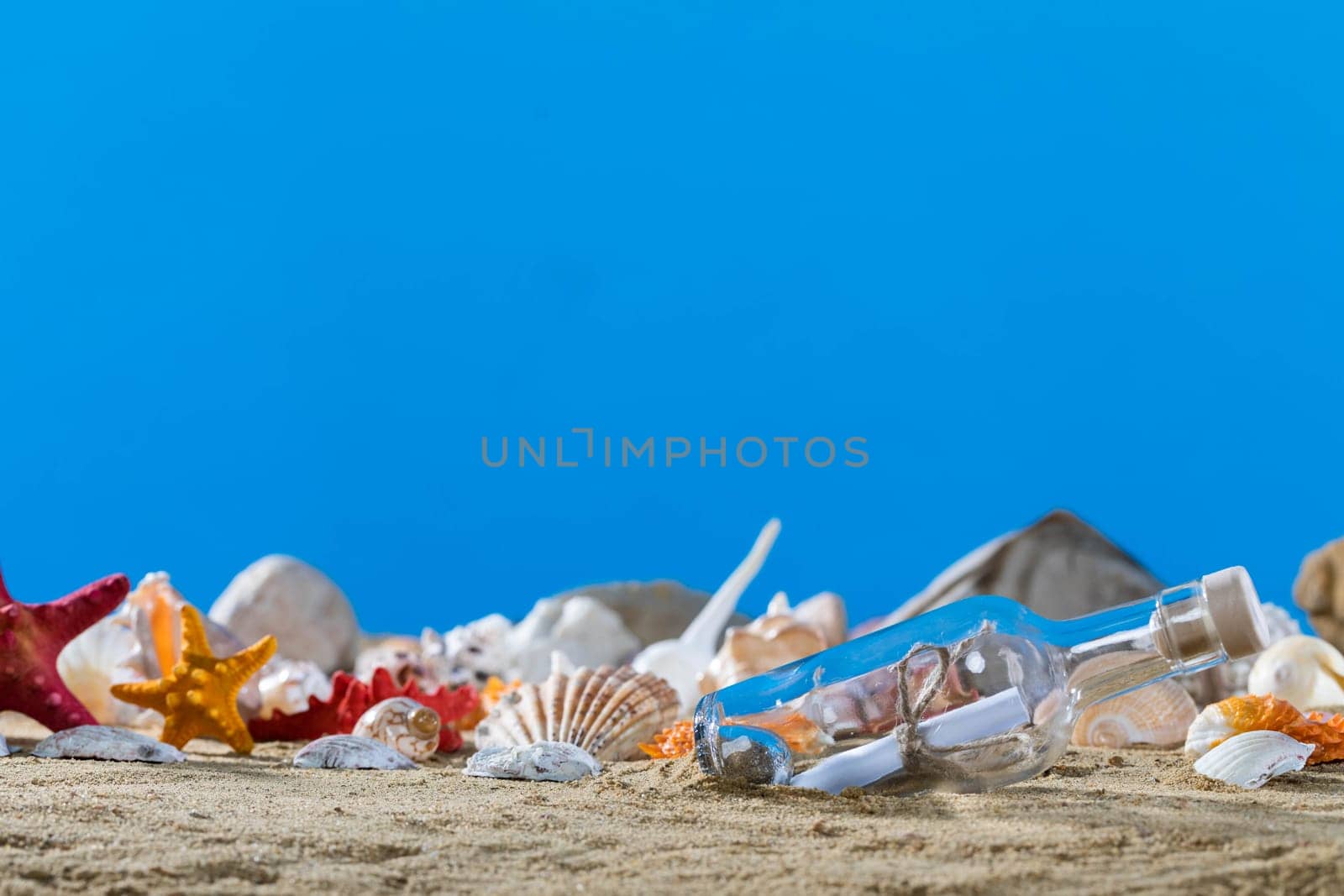 A glass bottle corked with a letter inside was on one of the sea wild beaches. Blue sky.