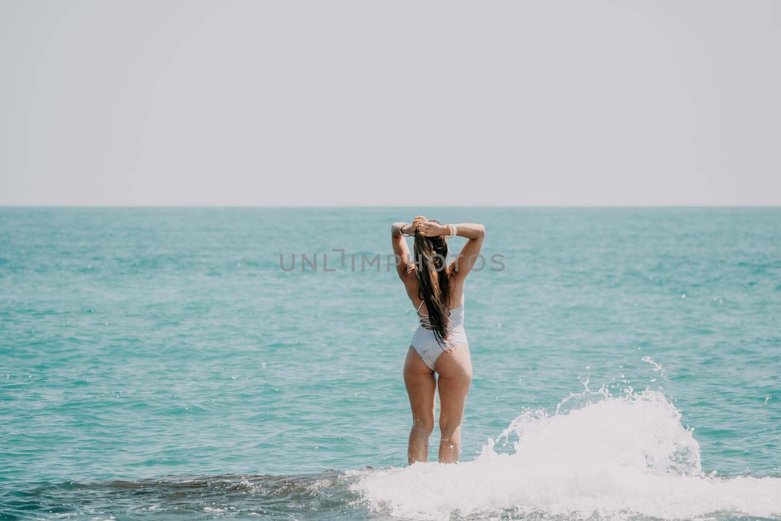 Woman sea yoga. Back view of free calm happy satisfied woman with long hair standing on top rock with yoga position against of sky by the sea. Healthy lifestyle outdoors in nature, fitness concept by panophotograph