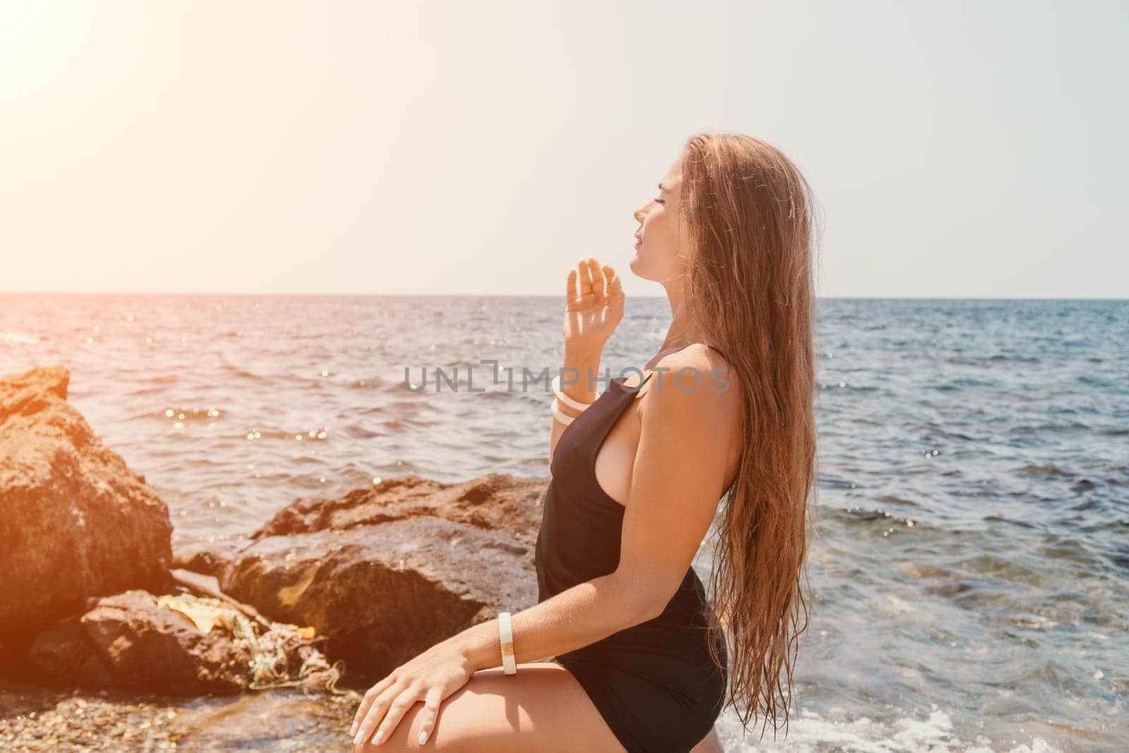 Woman summer travel sea. Happy tourist in hat enjoy taking picture outdoors for memories. Woman traveler posing on the beach at sea surrounded by volcanic mountains, sharing travel adventure journey by panophotograph