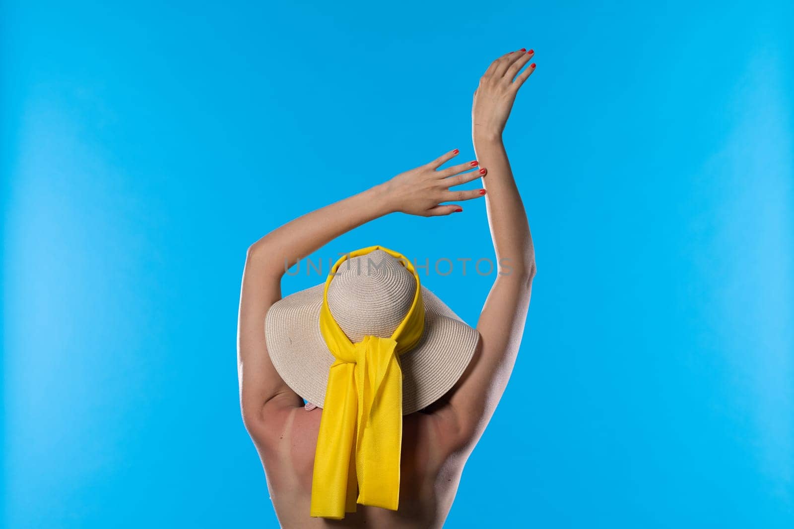The woman stretches holding her hands above her head on a sunny day.