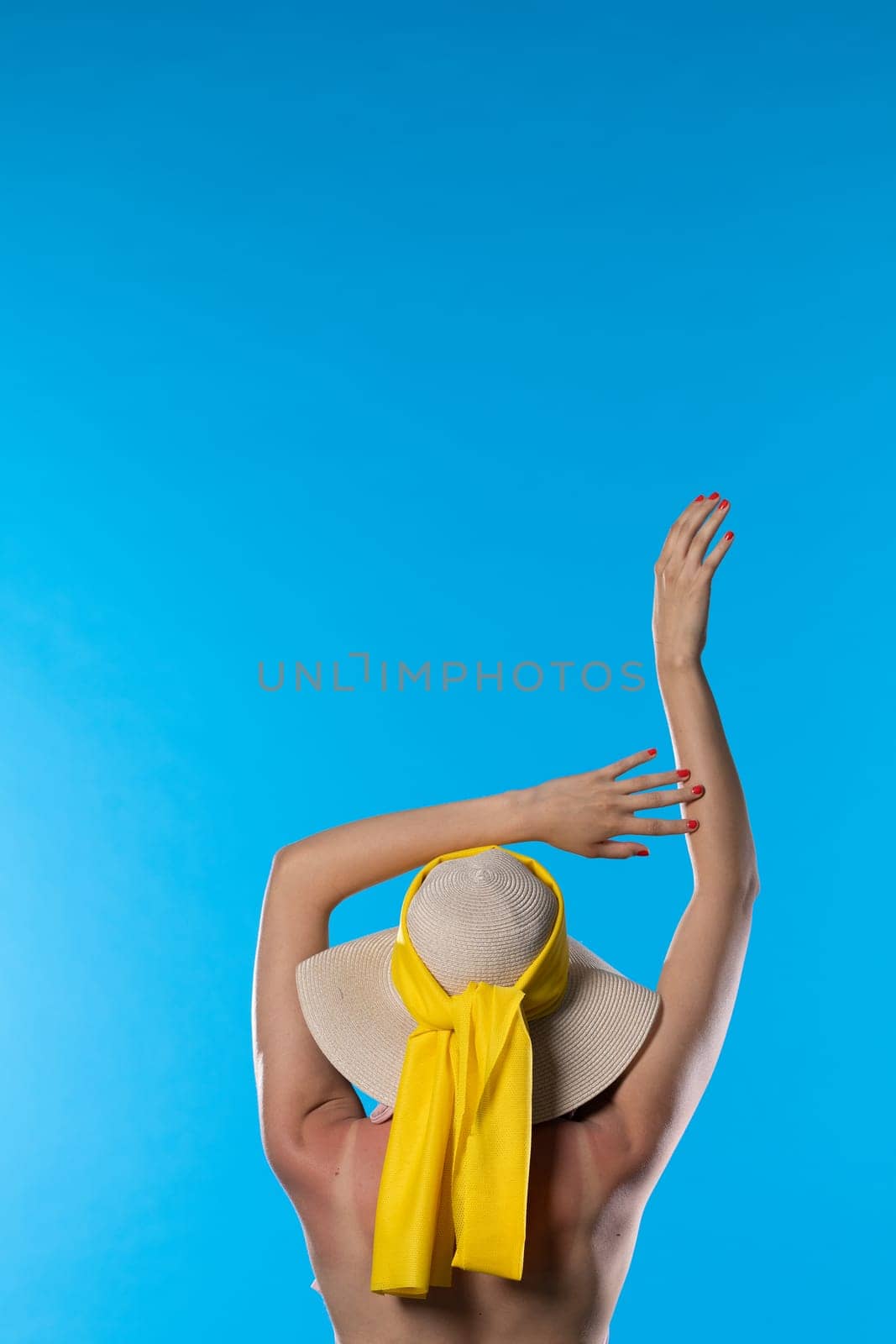 The woman stretches holding her hands above her head on a sunny day.