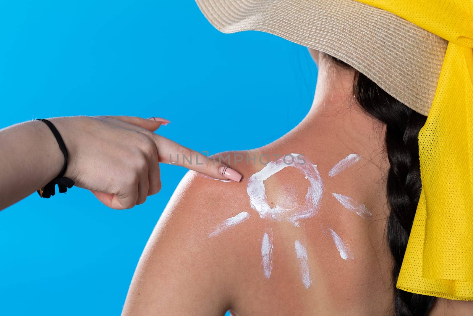 When spreading cream on her back, a friend makes a finger drawing on the patch and shoulder.