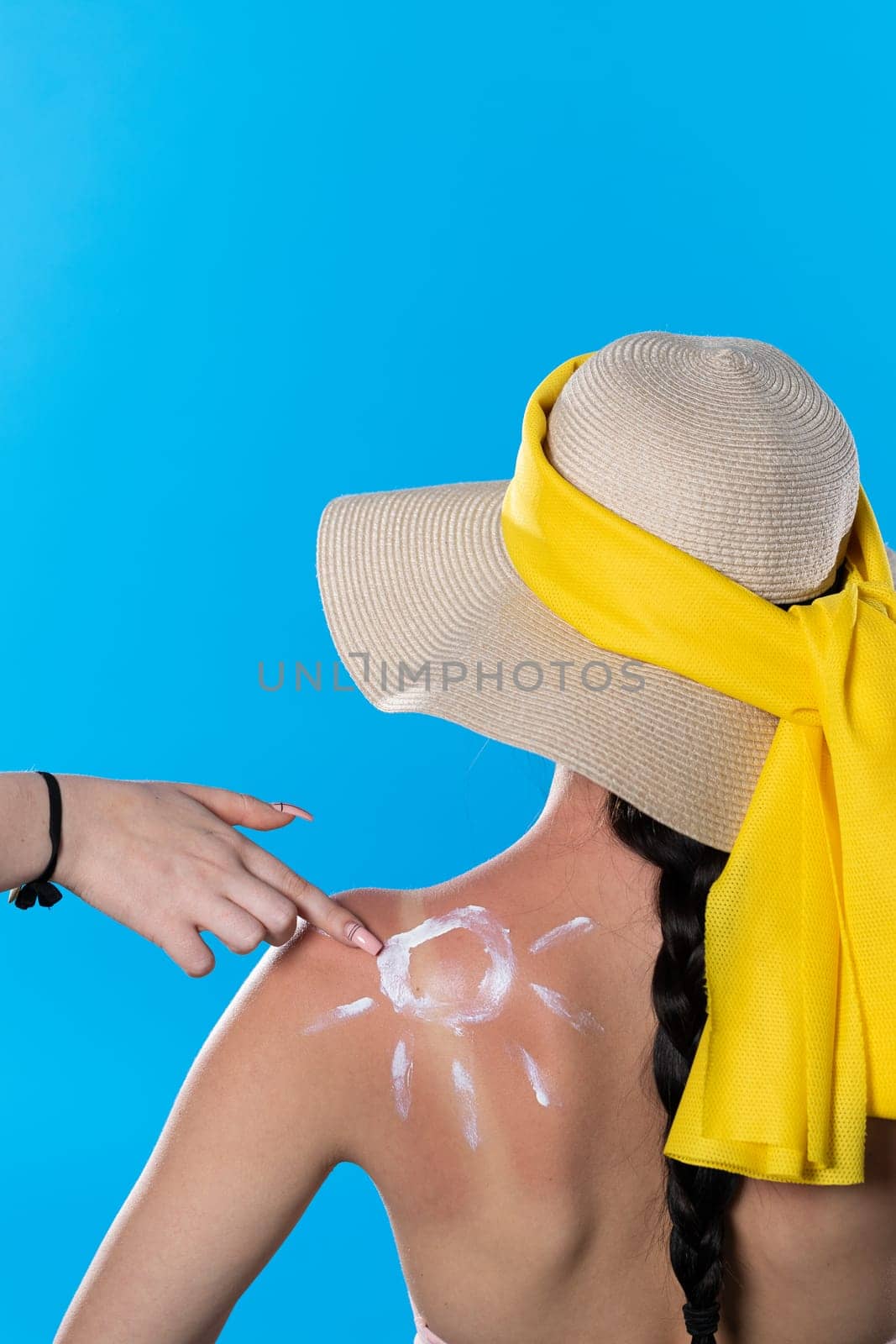 When spreading cream on her back, a friend makes a finger drawing on the patch and shoulder.