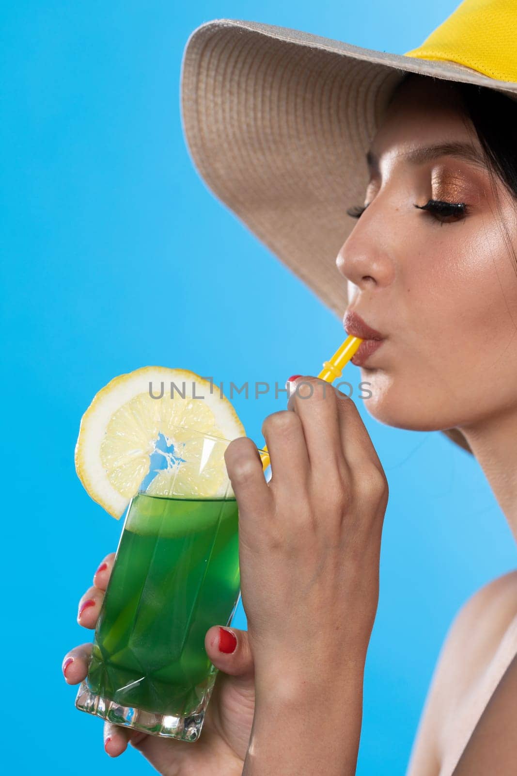 A teenager sipping a cold alcoholic drink through a straw during a hot summer.