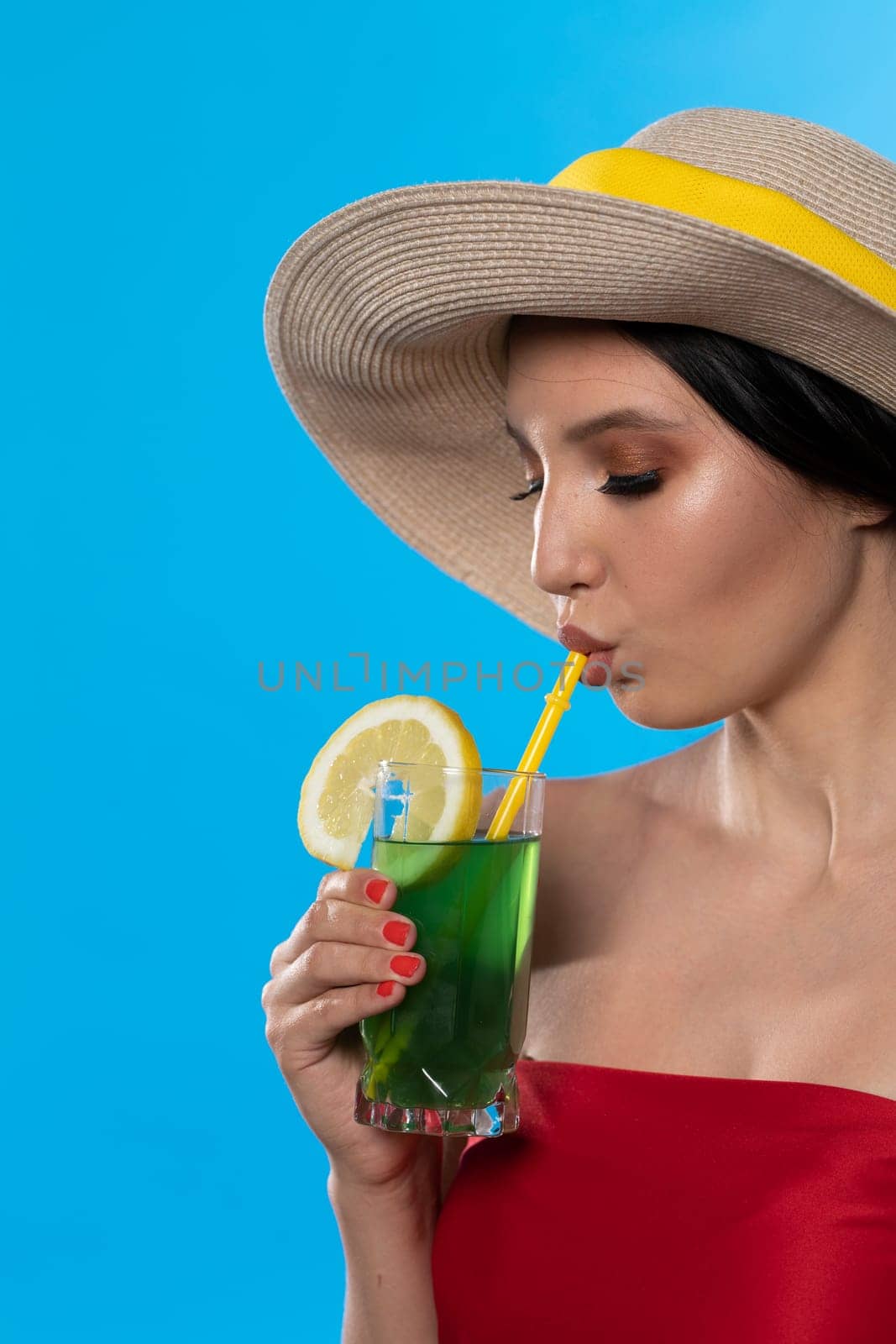 A teenager sipping a cold alcoholic drink through a straw during a hot summer.