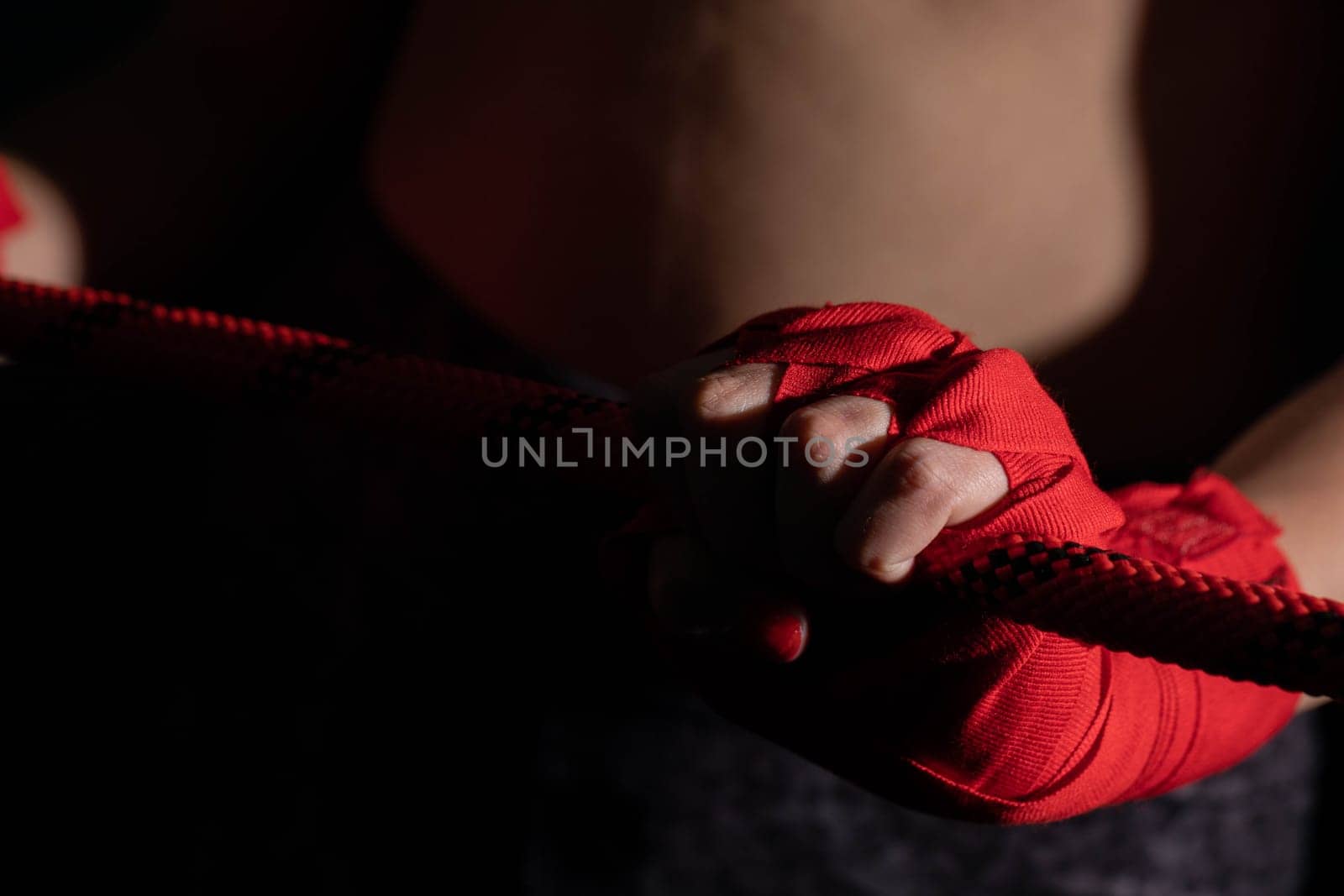 A tightly clenched hand on the boxing ring. A player strongly focused before her life fight .