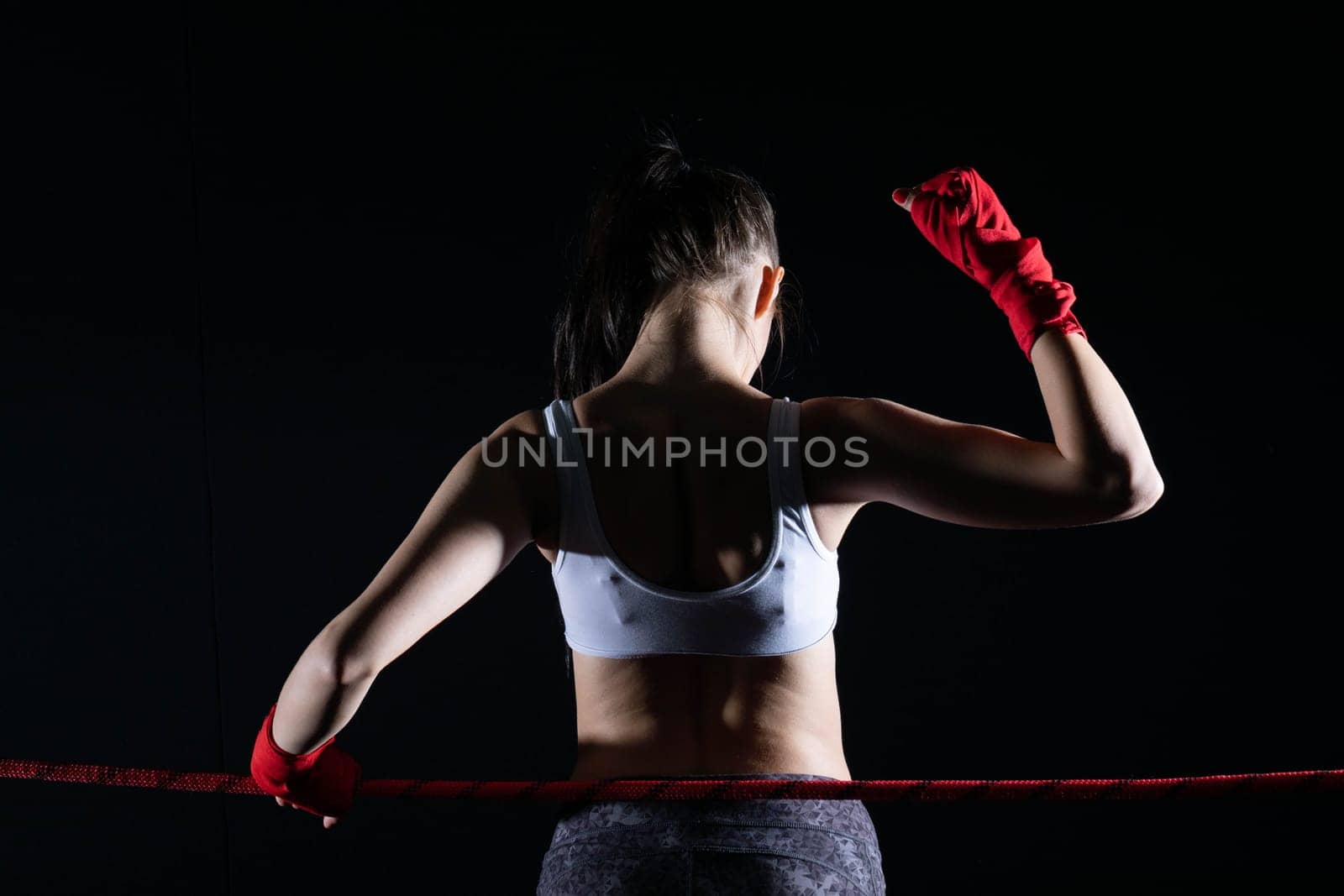 The fighter won her first fight. The woman raised her hands in evidence of winning the fight.