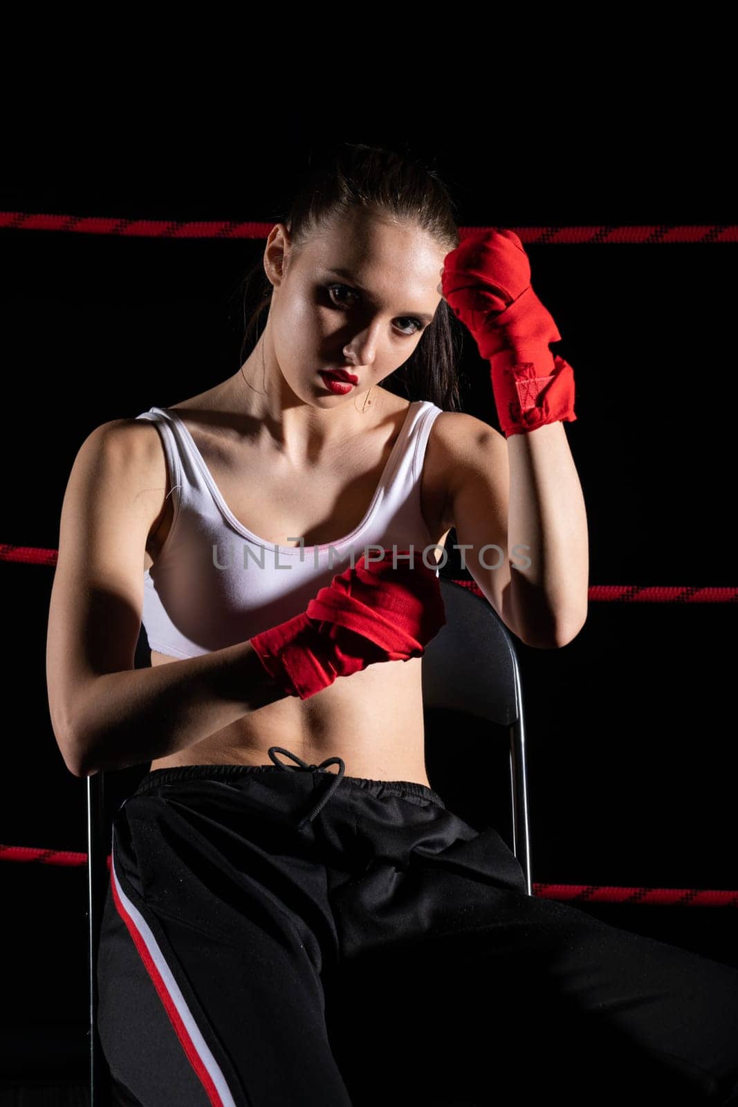 A lost fight of a strong player. He is sitting in a chair. Right after losing the fight. Sad woman after a fight in the ring.