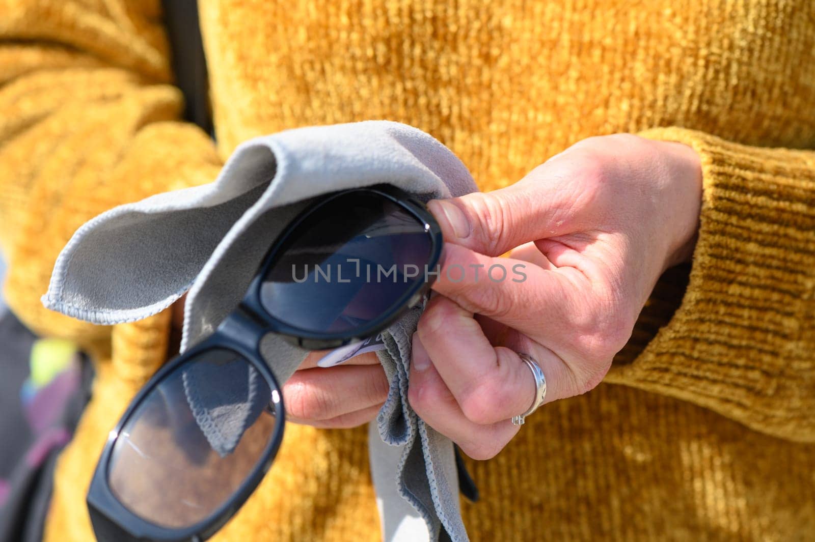 female hands wiping sunglasses with a napkin 5
