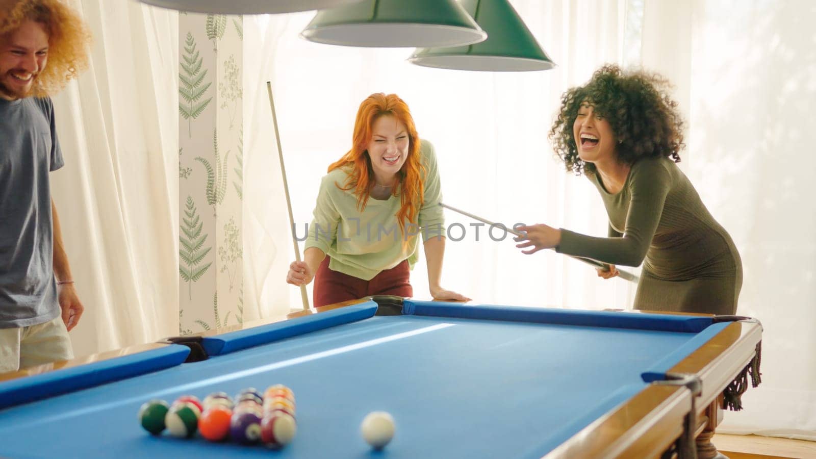 Friends laughing when woman playing awful at pool trying to hit the ball without luck
