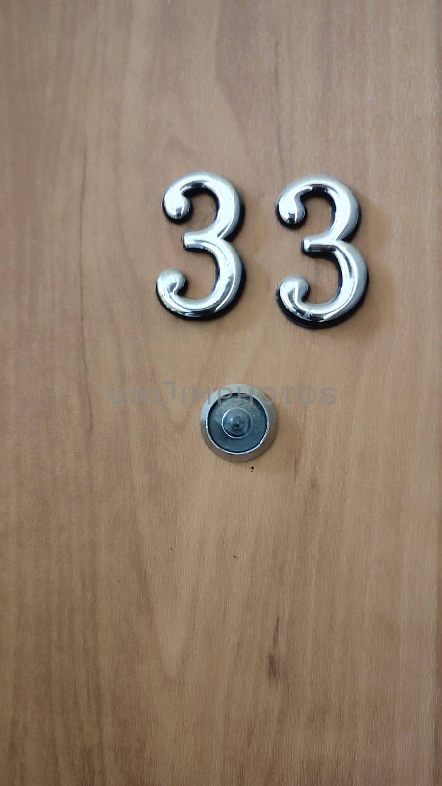 numbers 33 on a white exterior apartment door, symbol objects, sky. High quality photo