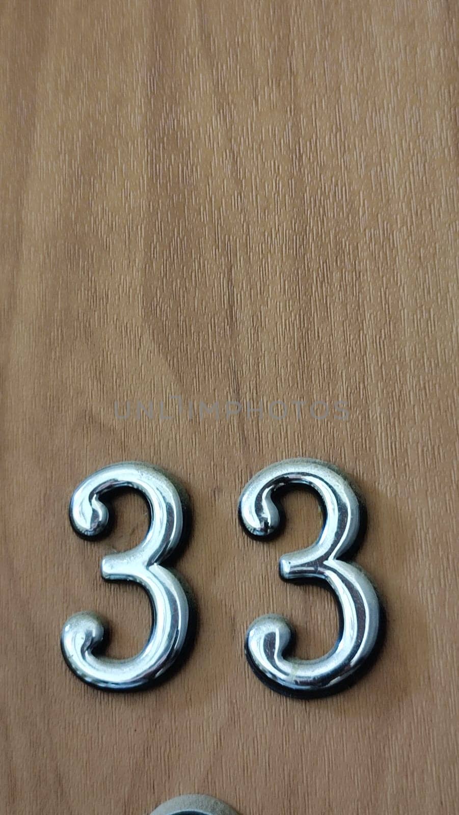 numbers 33 on a white exterior apartment door, symbol objects, sky. High quality photo