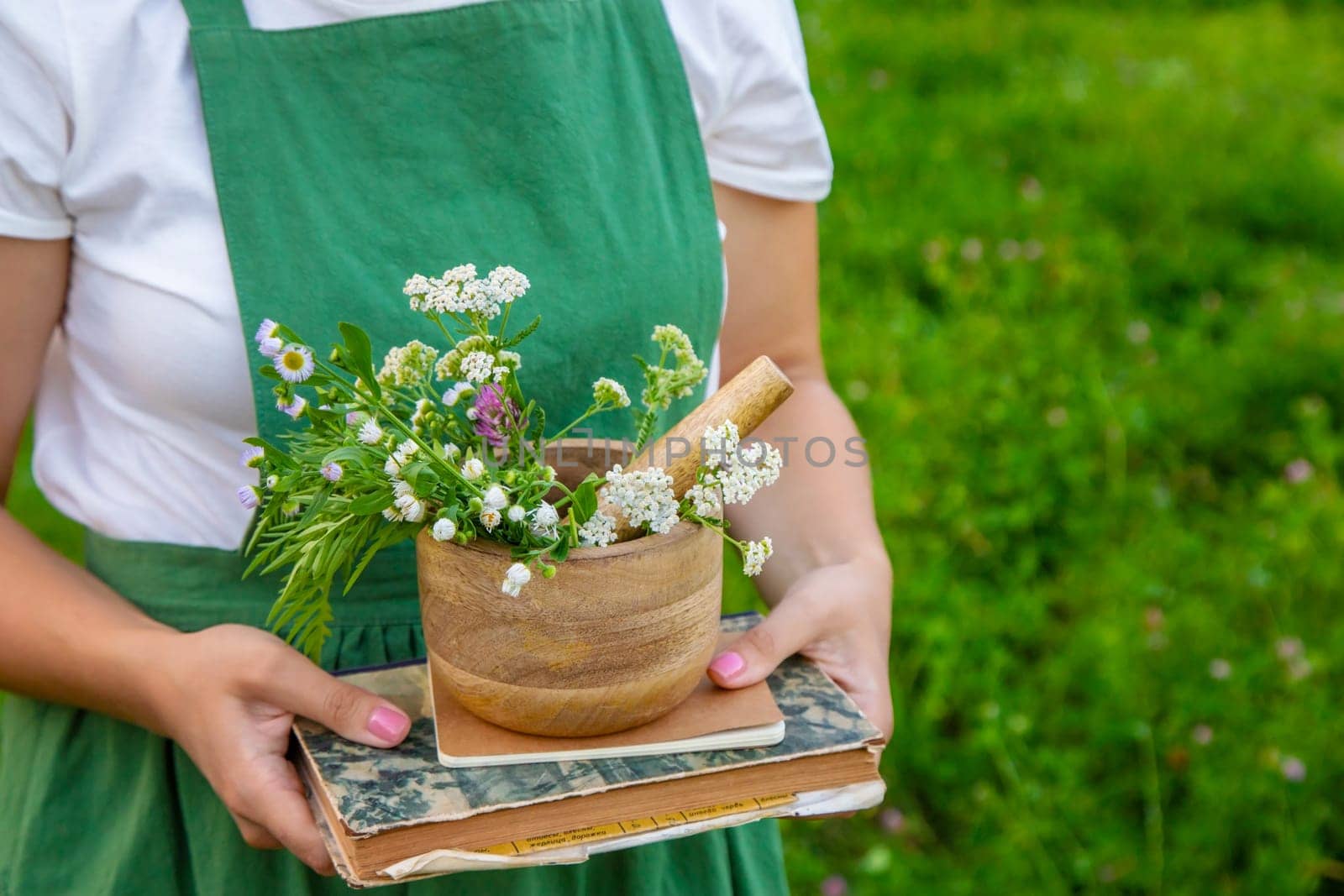 A woman collects medicinal herbs and makes herbal tincture