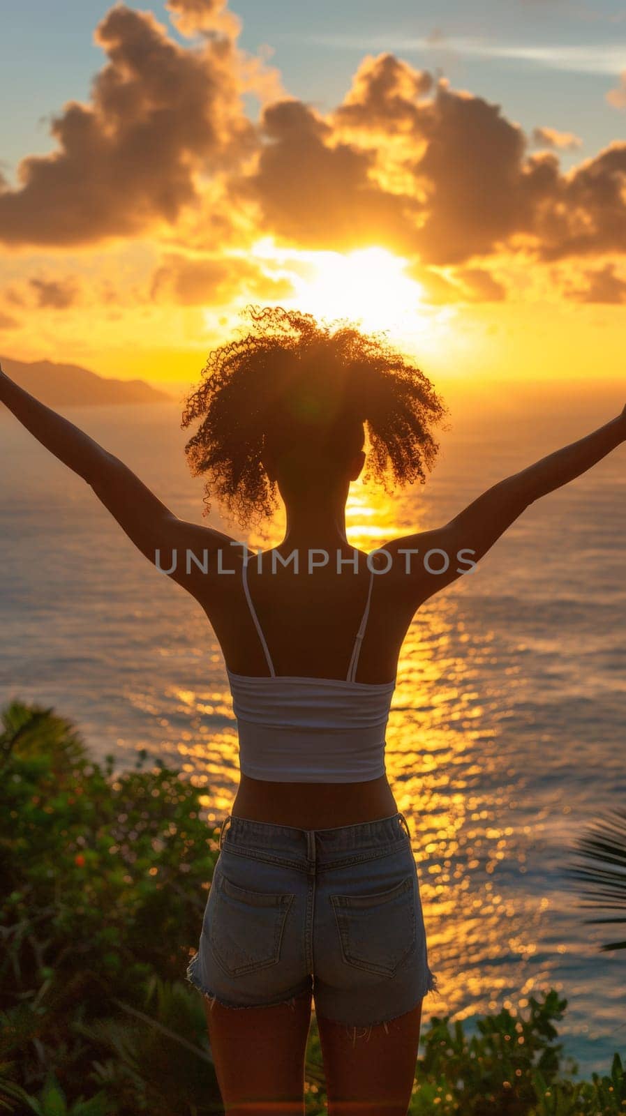 A woman standing on a beach with her arms outstretched