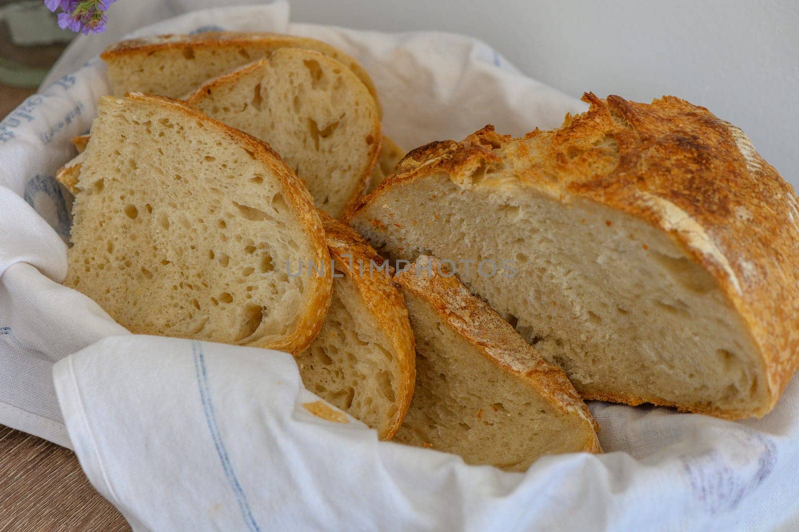 Close up of a loaf of homemade sourdough bread in a bread bininterior background 2