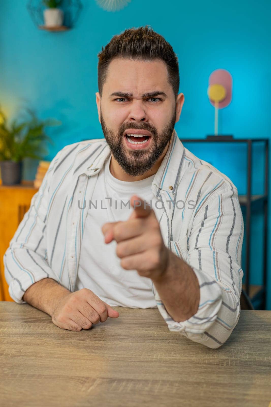 Conflict quarrel negotiation. Portrait of angry businessman engaged in webcam online video call at home office. Upset freelancer guy discussing conversation after analyzing financial report. Vertical