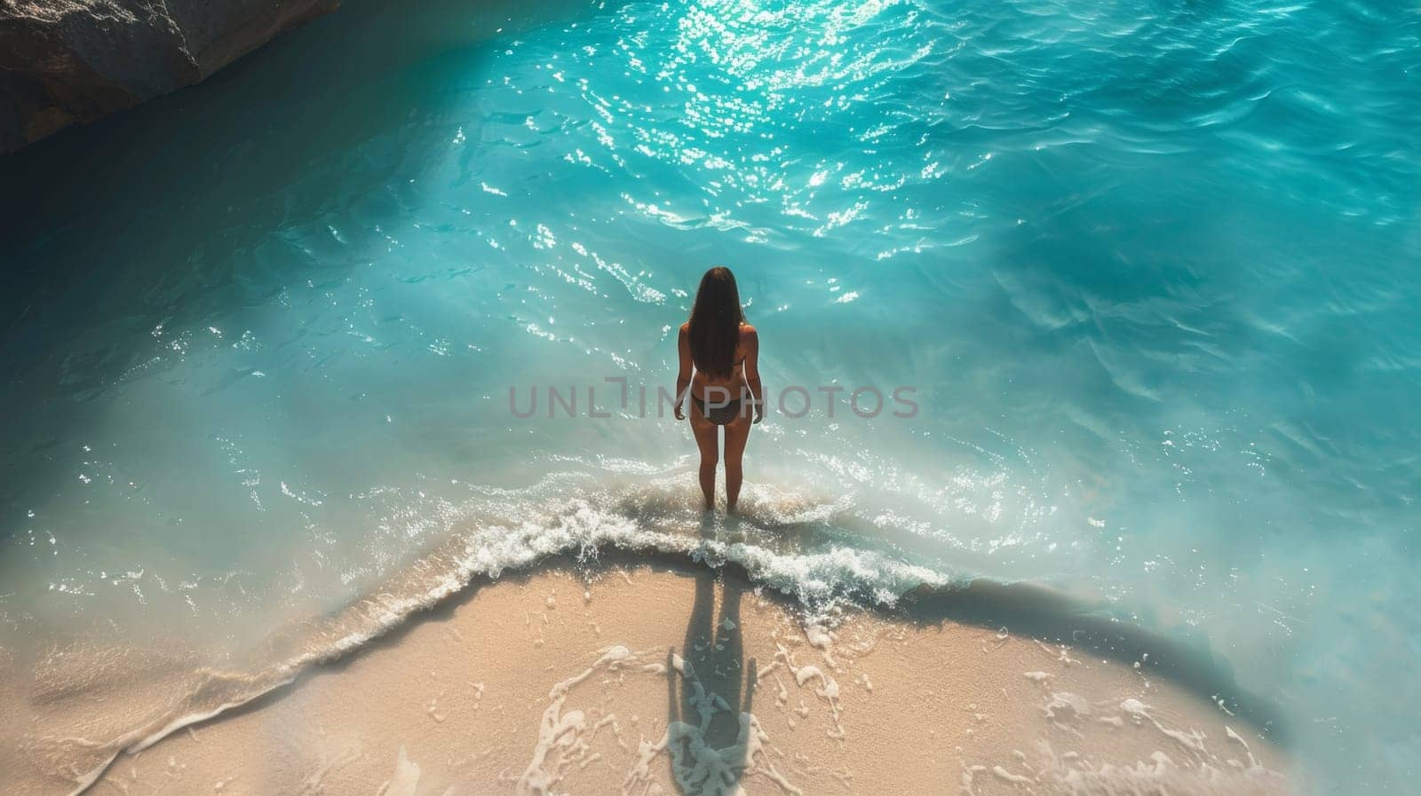 A woman standing on a beach in the ocean looking out