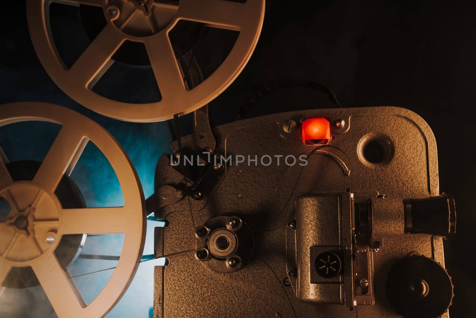 Retro projector playing motion picture in dark room. Timeless flicker of old films. Vintage objects, cinema, Hollywood concept. Perfect for festival background, broadcasting equipment. High quality