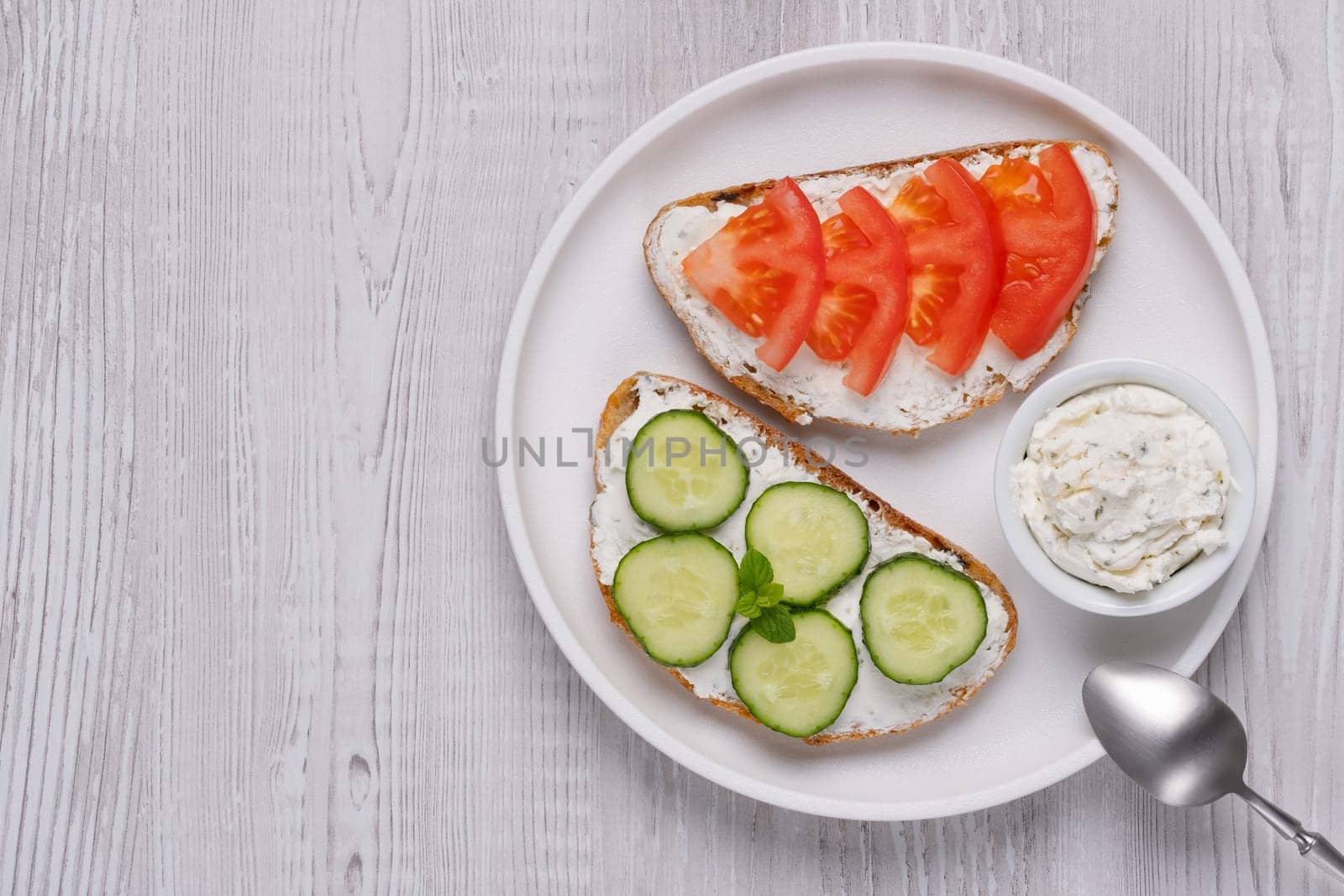 Healthy sandwiches with white cottage cheese, cucumber and tomato, with copy space for text.