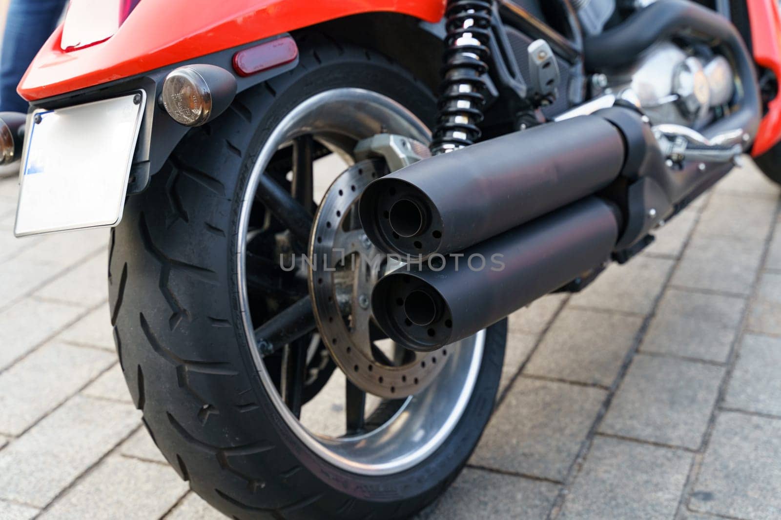 Warsaw, Poland - August 6, 2023: A Harley Davidson motorcycle stands in a parking lot, detailed rear view.