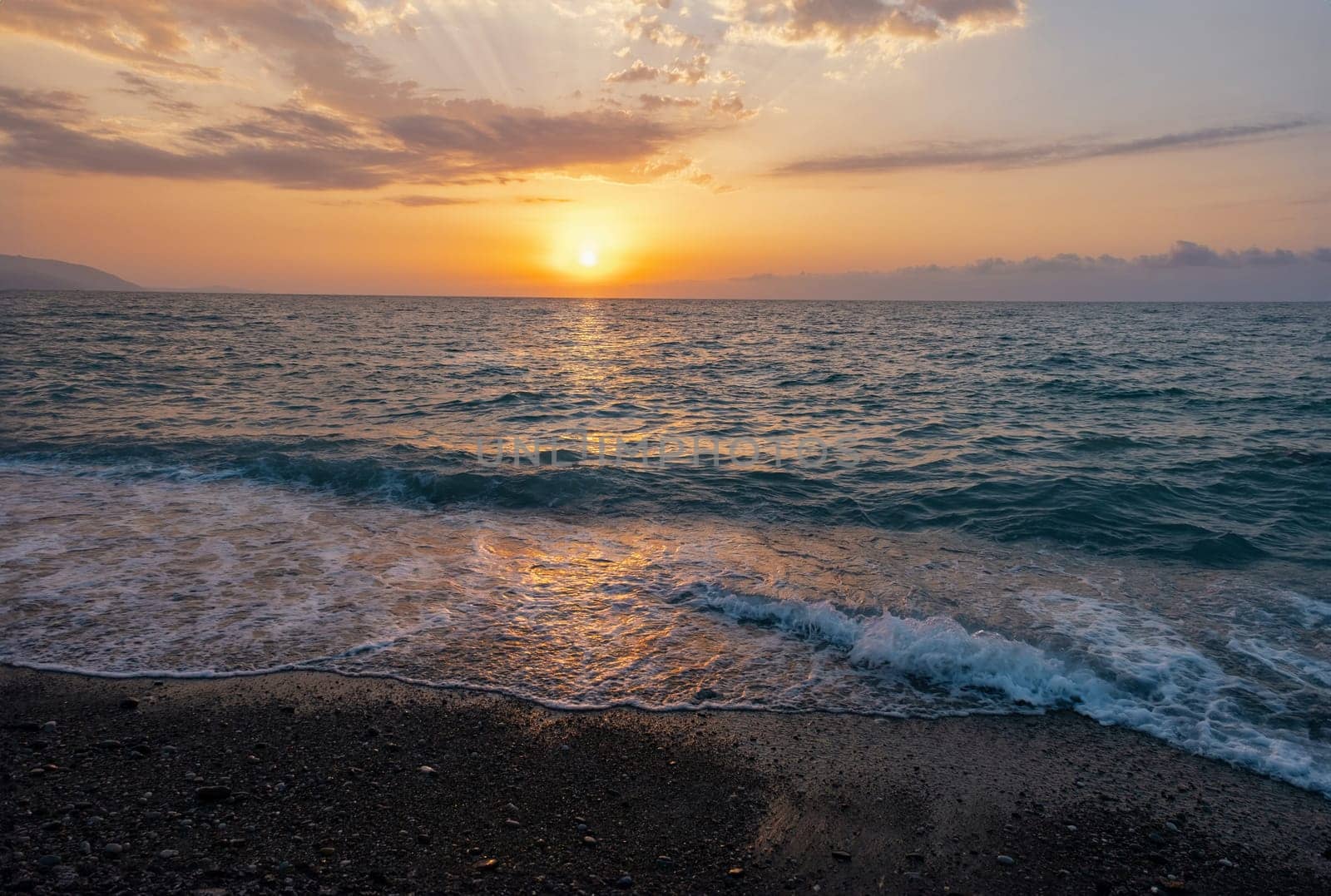 The picturesque sea at sunset. Sunset on the Black Sea with the sun, Abkhazia. Colorful sunset with waves.