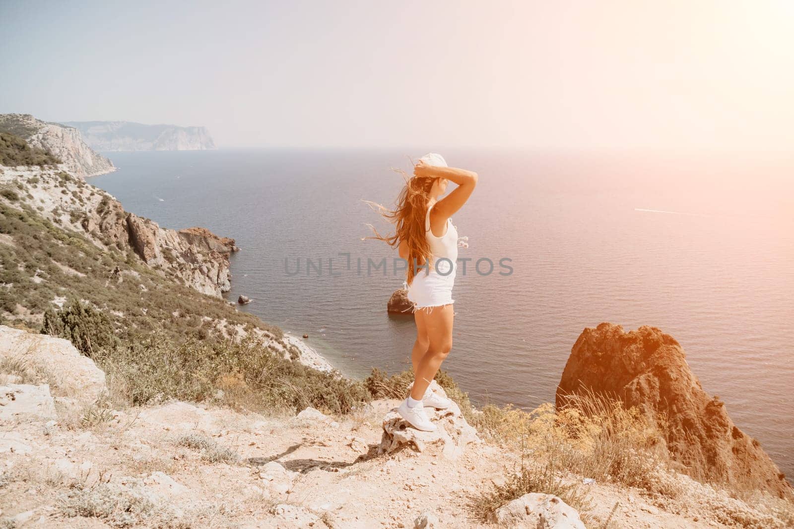 Woman summer travel sea. Happy tourist enjoy taking picture outdoors for memories. Woman traveler posing over sea bay surrounded by volcanic mountains, sharing travel adventure journey by panophotograph