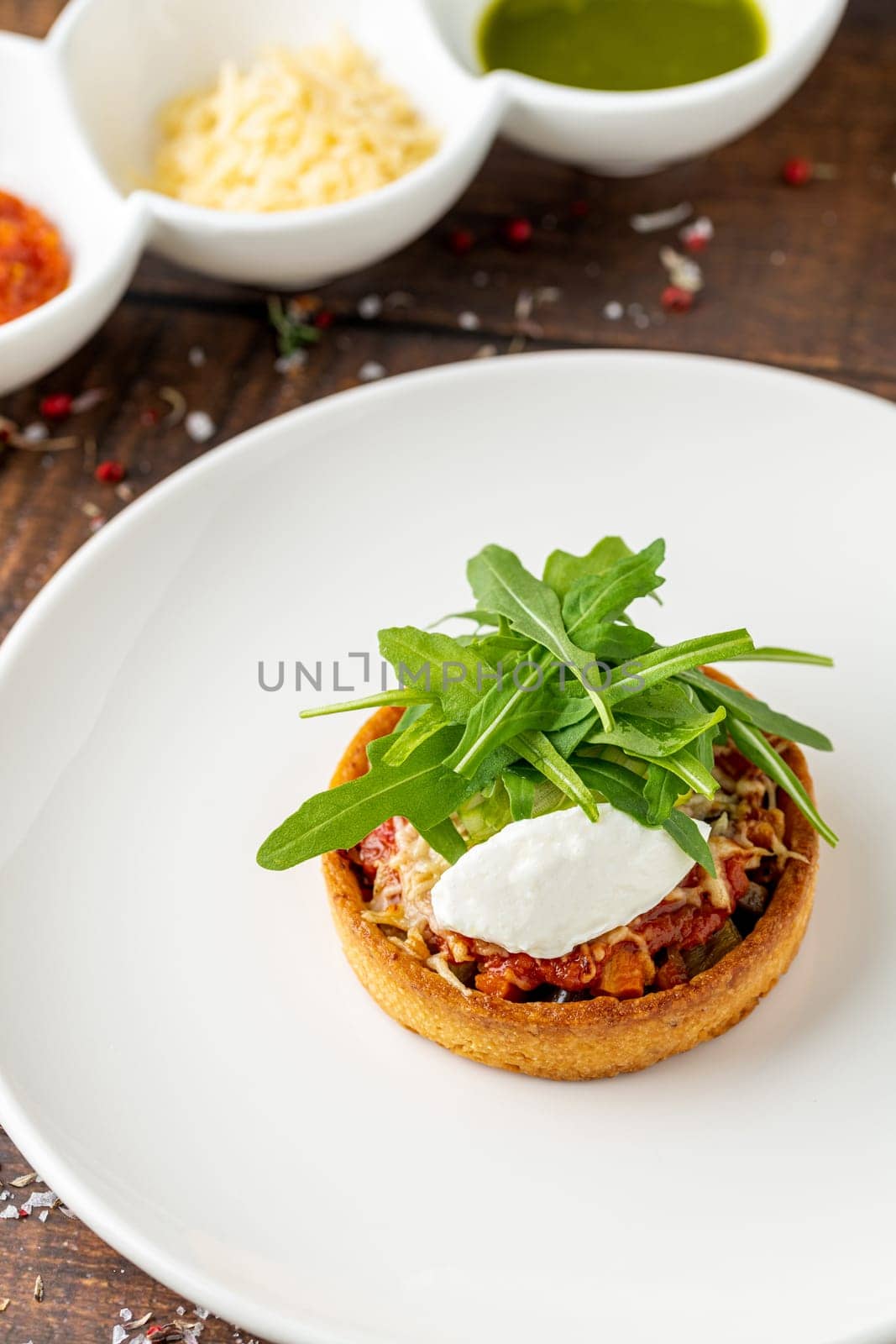 Italian dish Tortino di Verdure served on a white plate on wooden table