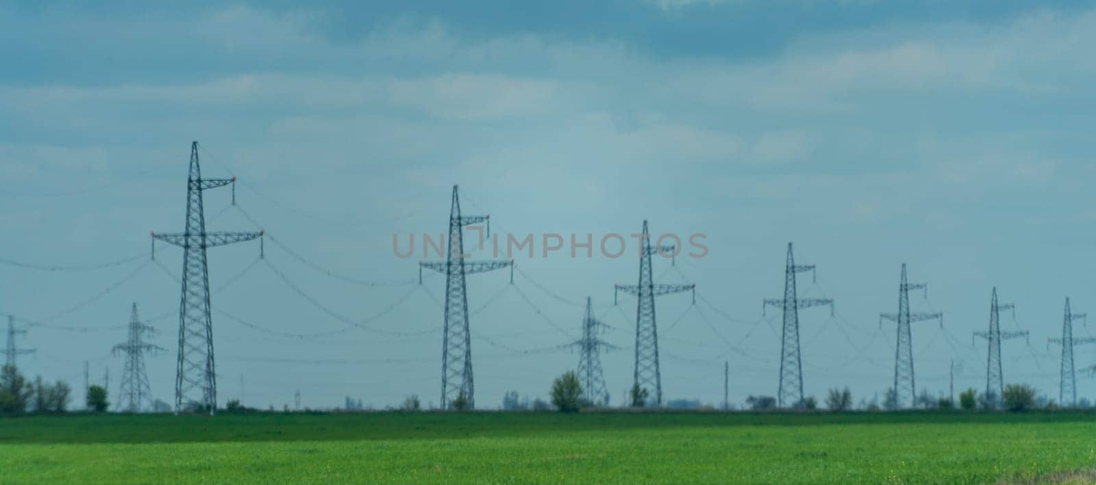 High voltage towers with sky background. Power line support with wires for electricity transmission. High voltage grid tower with wire cable at distribution station. Energy industry, energy saving.