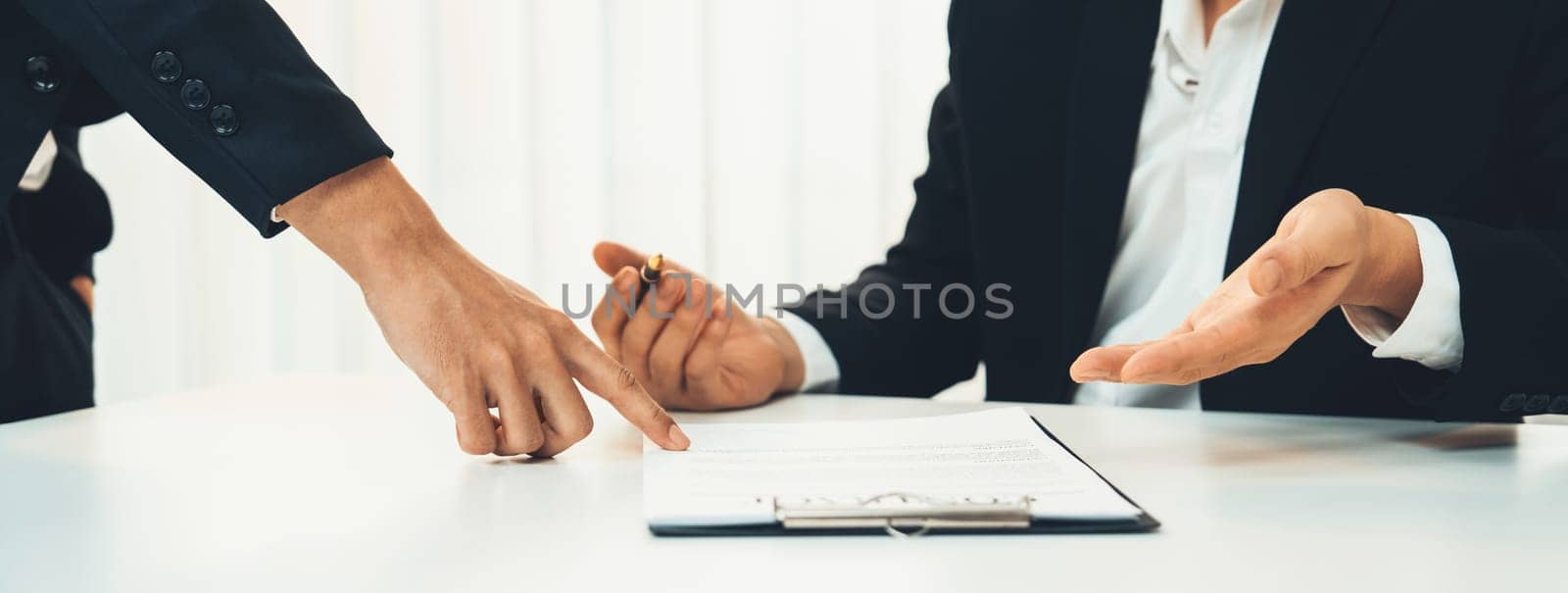 Business executive signing contract agreement document on the bale with the help from company attorney or lawyer service in law firm office. Business investing and finalizing legal processing. Shrewd