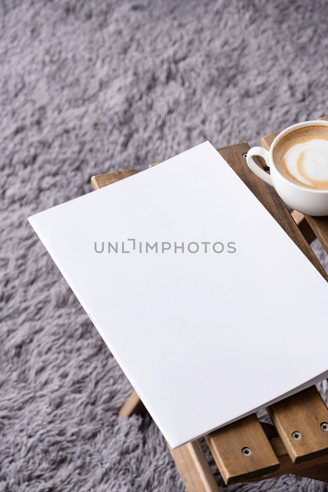blank magazine mockup on wooden chair with cappuccino, pen and grey rug by Desperada