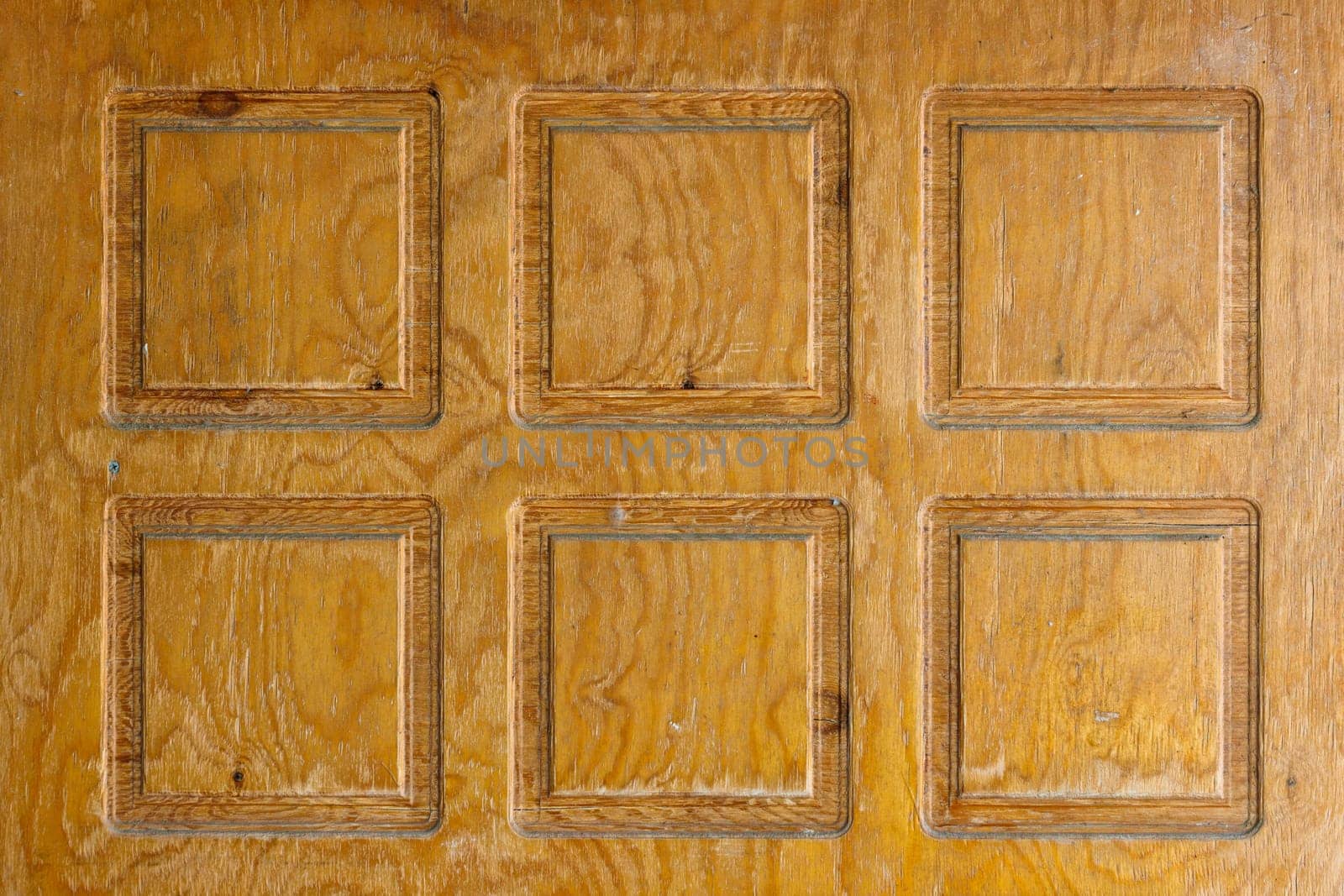 Brown plywood door texture with square decorative recessions carved into it