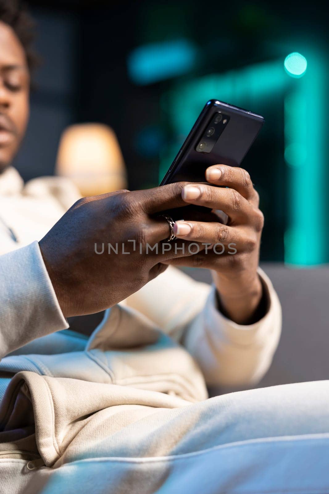 Focus on smartphone used by man in blurry background to compose messages by DCStudio