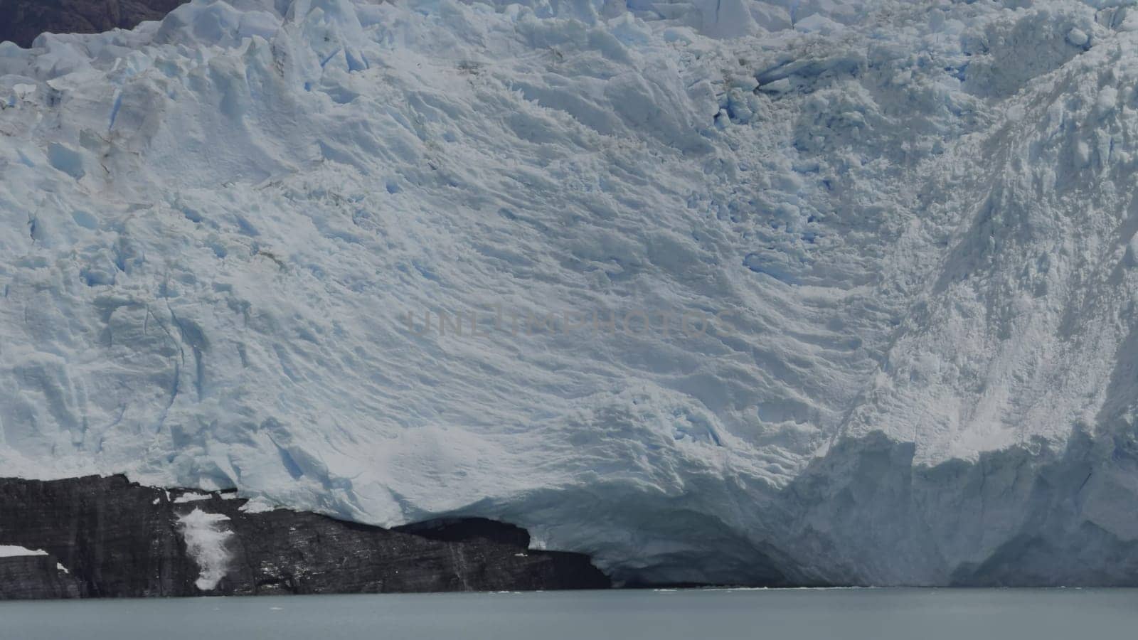 Captured slow-mo footage of a glacier calving, with chunks of ice plunging into the sea and creating splashes.