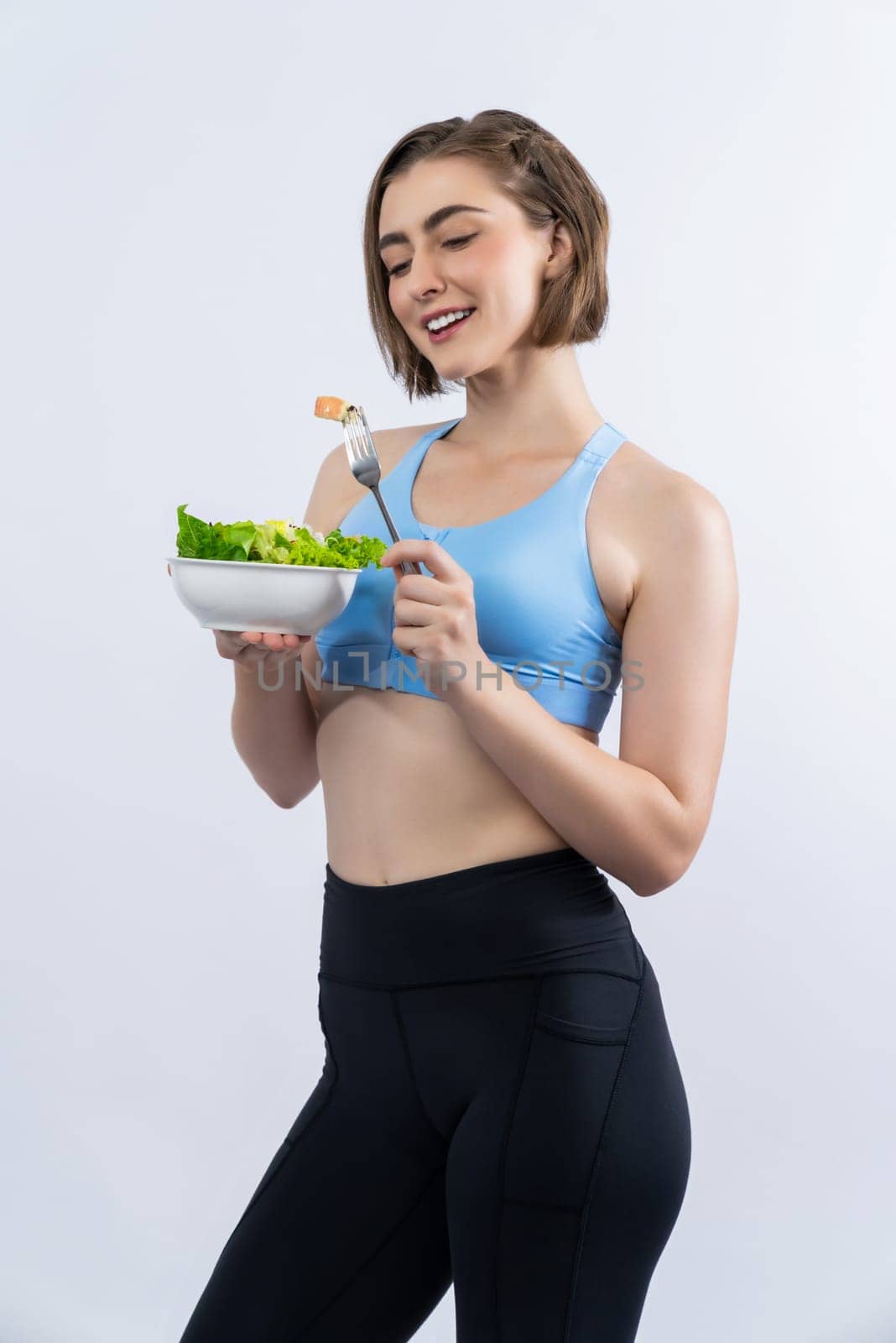 Full body length gaiety shot athletic and sporty young woman with healthy vegan food in standing posture on isolated background. Healthy active and body care by vegetarian lifestyle.