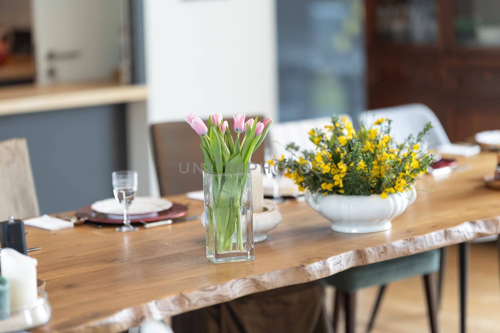 a vase with flowers on the dining table is a festive setting - telephoto