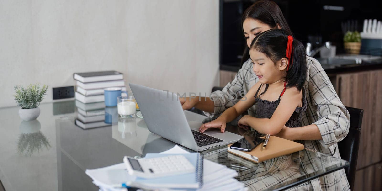 business woman work from home and take care of her child while working.