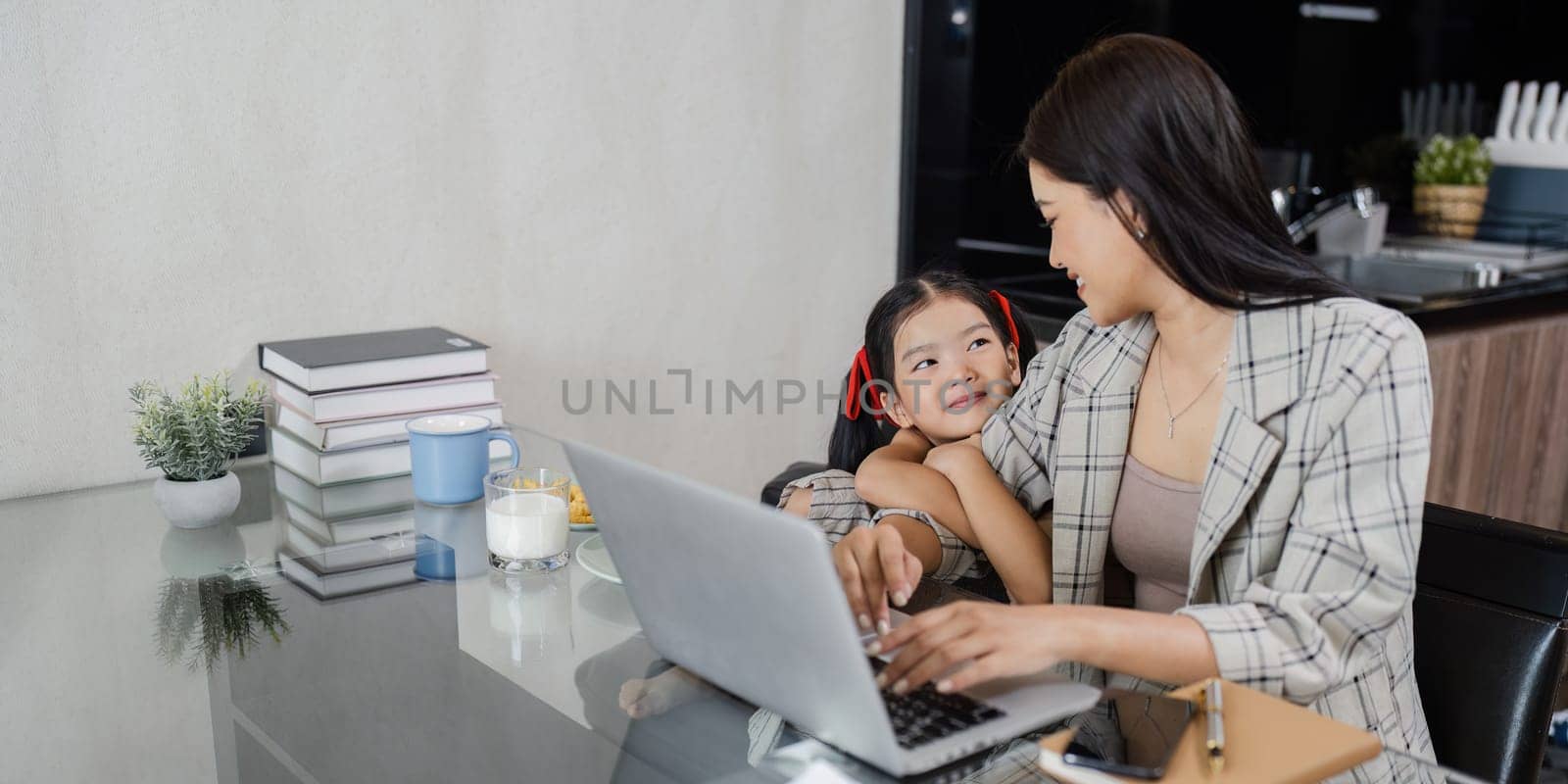 business woman work from home and take care of her child while working by itchaznong