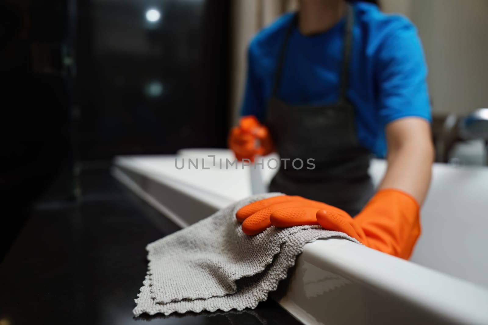 Cleaning online service. yong woman housekeeper cleaning bathtub in bathroom with a cloth. House cleaning service concept.