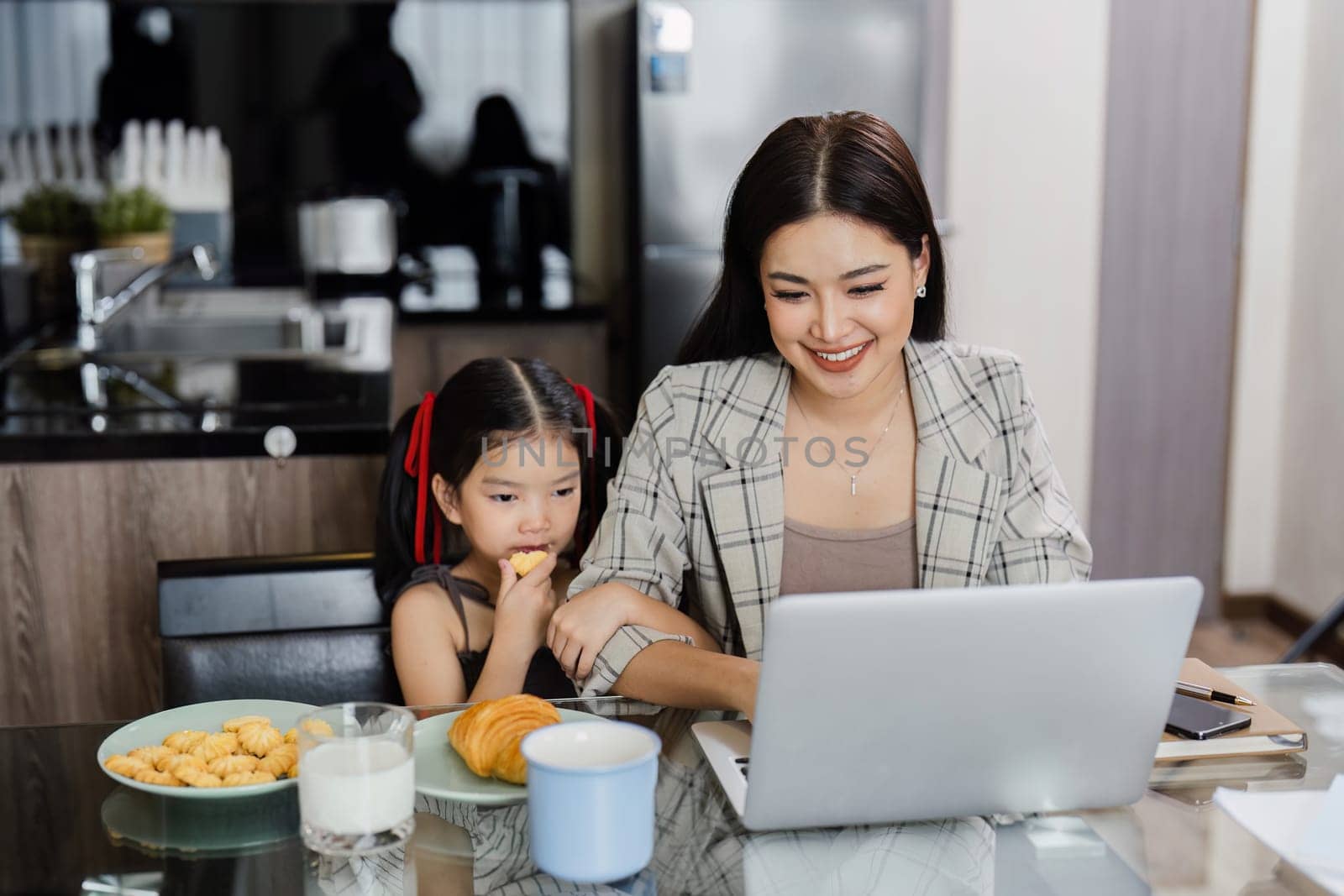business woman work from home and take care of her child while working by itchaznong